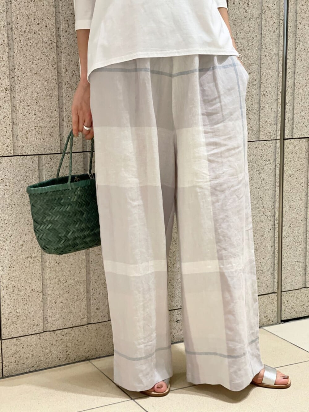 グレー系のその他パンツ、ホワイト系のTシャツ/カットソー、ホワイト系のサンダルを着用したレディースの春コーディネートの3枚目の写真