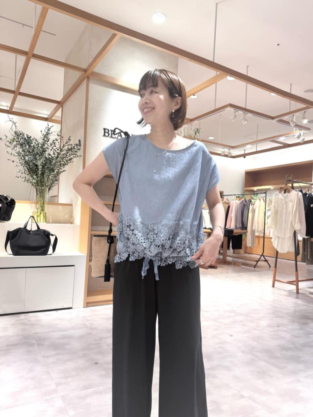 ブラック系のその他パンツ、ブルー系のシャツ/ブラウスを着用したレディースの春コーディネートの9枚目の写真