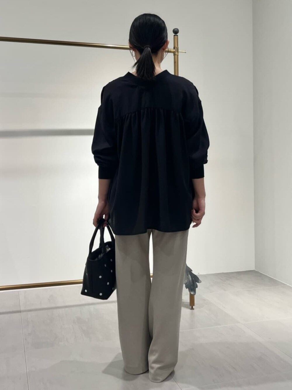 ブラック系のトートバッグ、ブラック系のシャツ/ブラウス、ベージュ系のその他パンツを着用したレディースの夏コーディネートの3枚目の写真