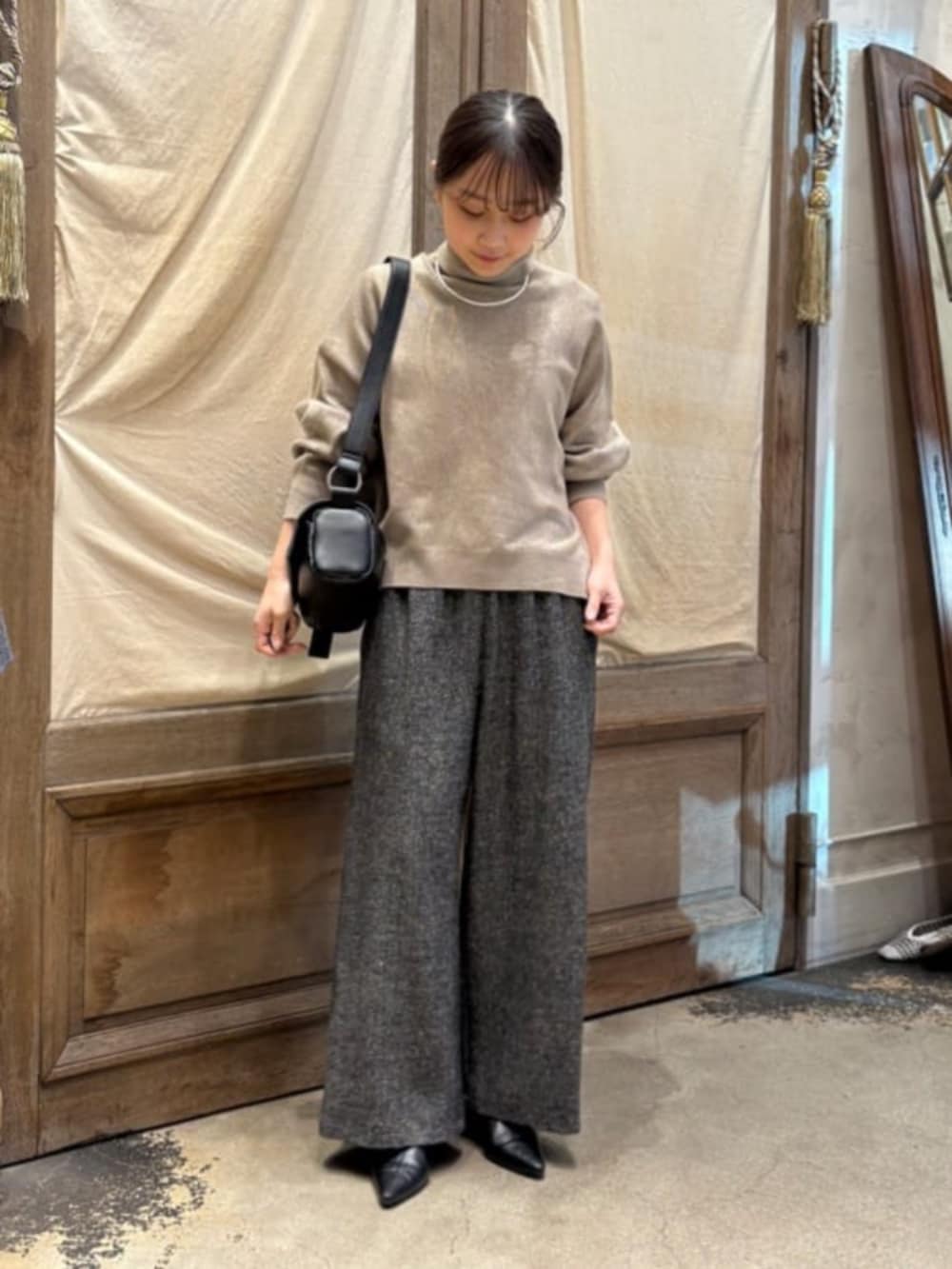 ブラック系のショルダーバッグ、ブラウン系のニット/セーター、グレー系のその他パンツを着用したレディースの秋コーディネートの2枚目の写真