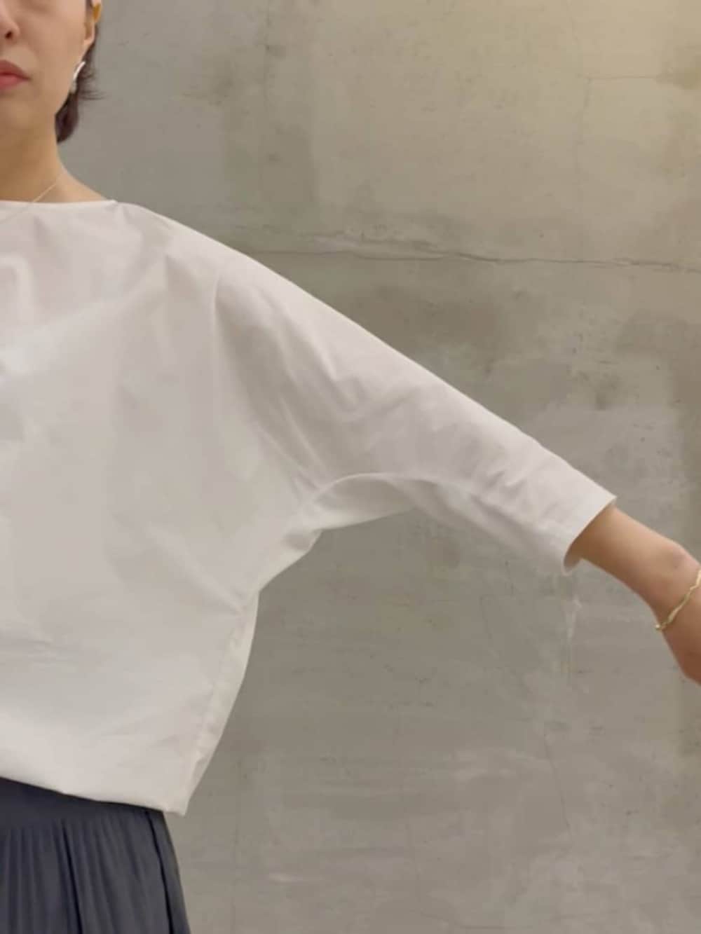 グレー系のスカート、ブラック系のショルダーバッグ、ホワイト系のシャツ/ブラウスを着用したレディースの春コーディネートの9枚目の写真