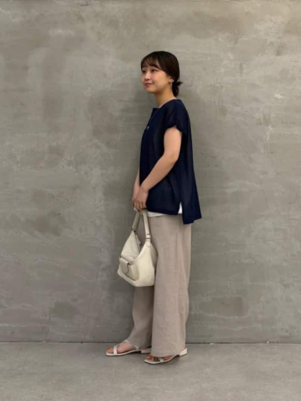 ホワイト系のトートバッグ、グレー系のその他パンツ、ブルー系のニット/セーターを着用したレディースの春コーディネートの7枚目の写真