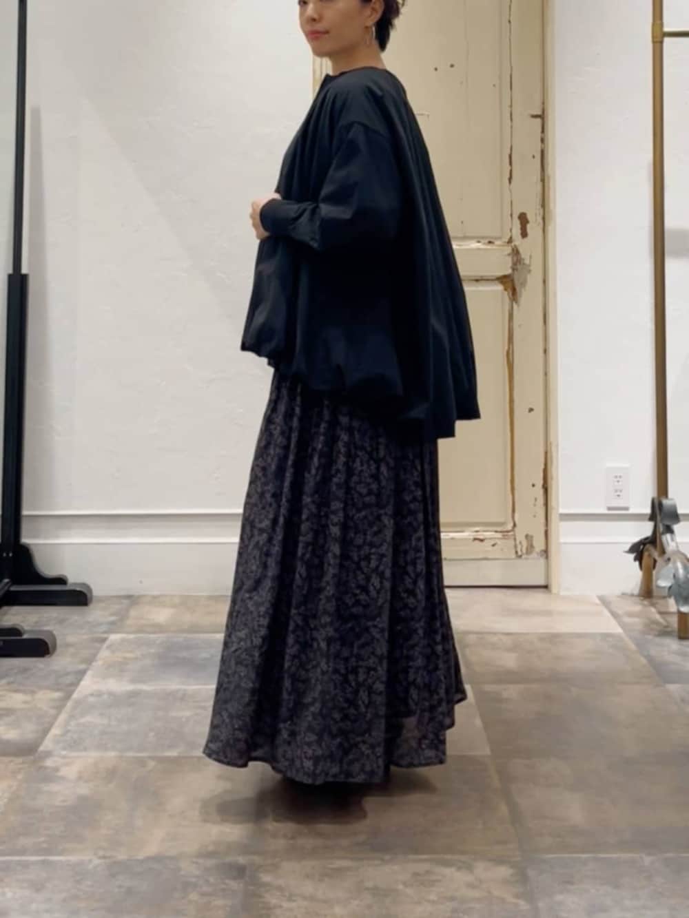 ブラック系のスカート、ベージュ系のショルダーバッグ、ブラック系のブルゾンを着用したレディースの冬コーディネートの3枚目の写真