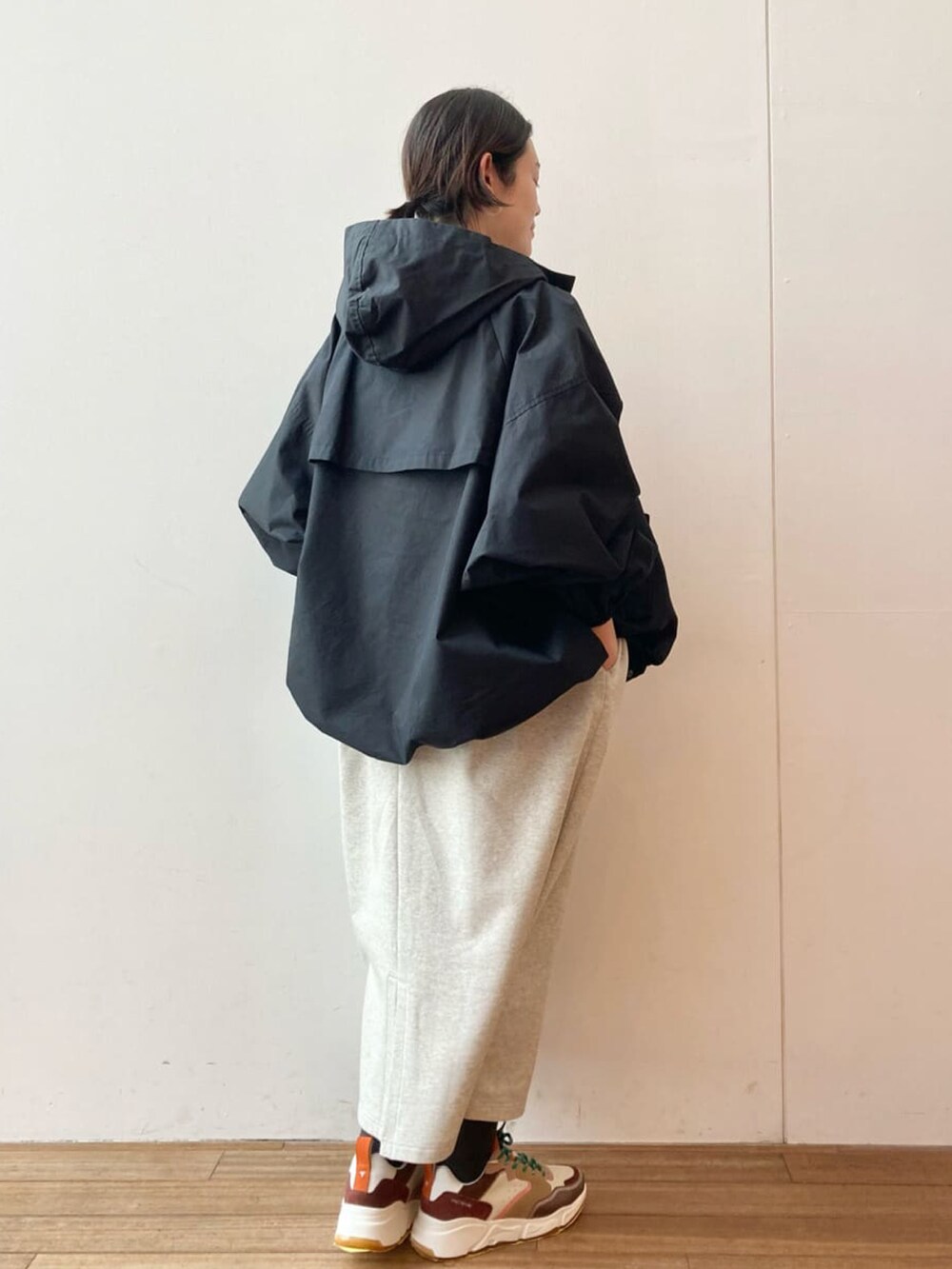 ブラック系のマウンテンパーカー、グレー系のワンピース、ブラウン系のスニーカーを着用したレディースの春コーディネートの3枚目の写真