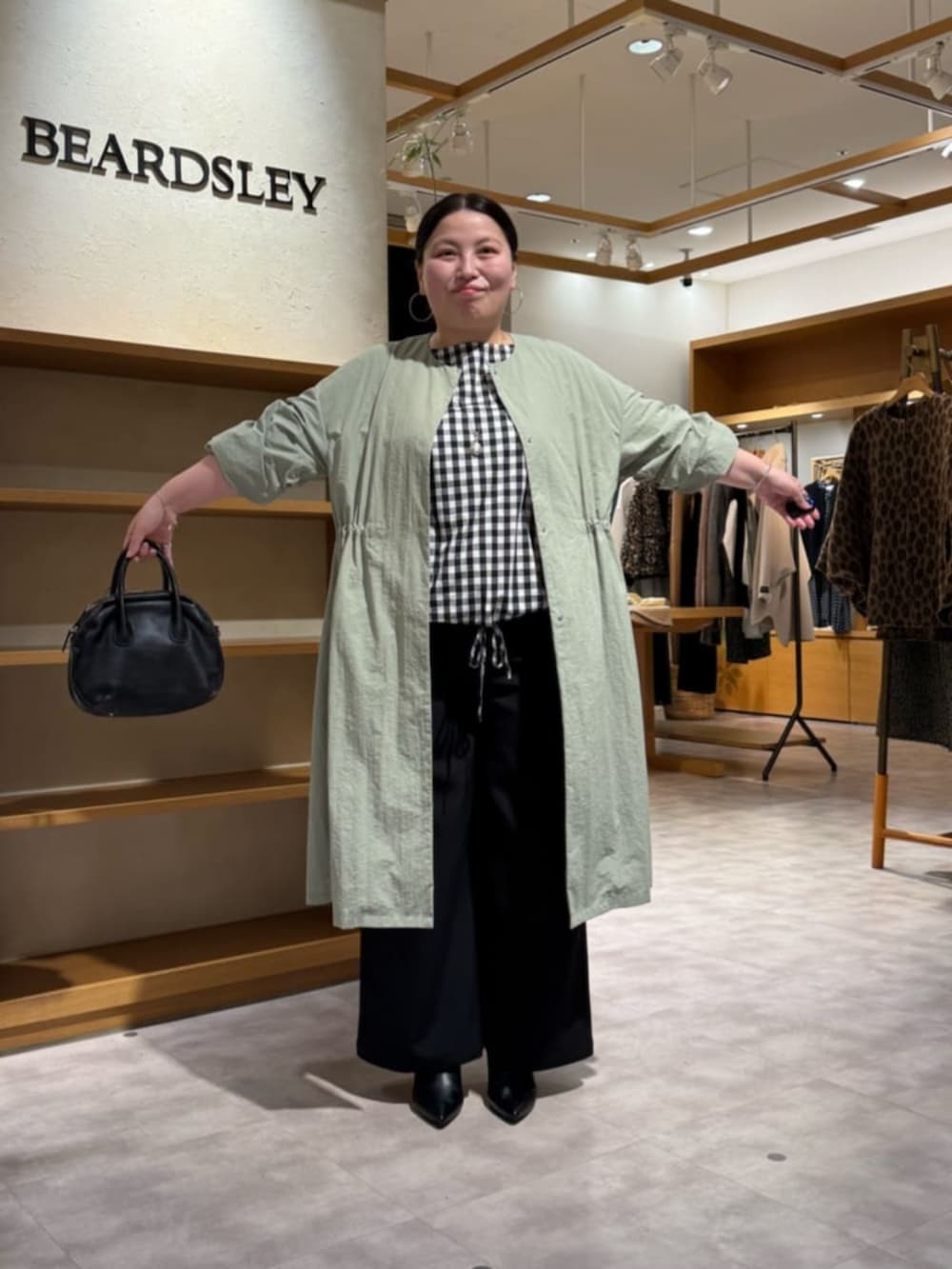 ブラック系のその他パンツ、ブラック系のシャツ/ブラウス、グリーン系のその他アウターを着用したレディースの冬コーディネートの5枚目の写真