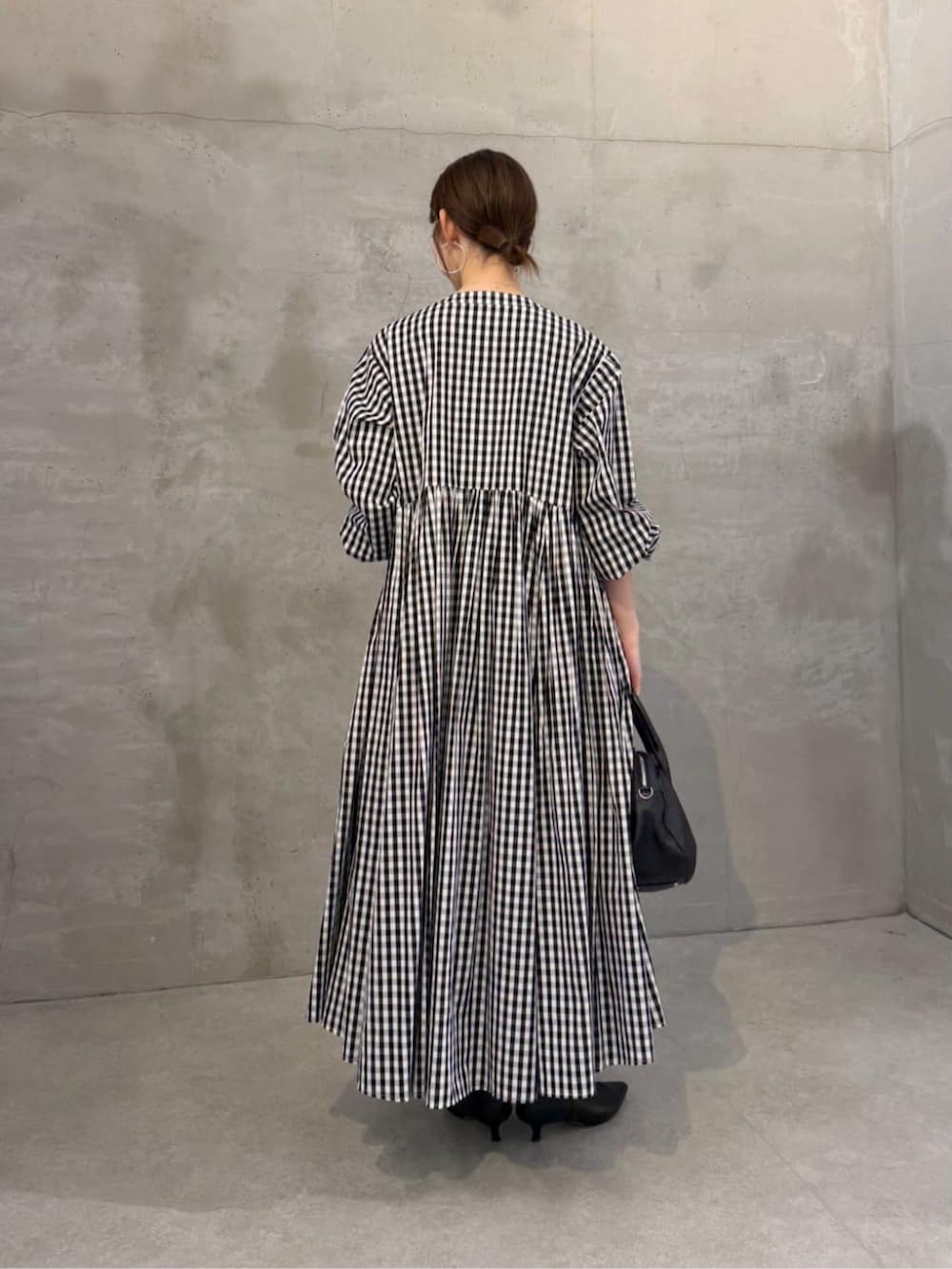 ブラック系のワンピースを着用したレディースの冬コーディネートの2枚目の写真