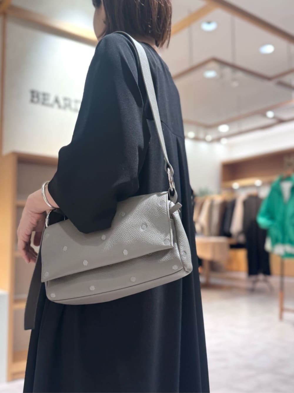 ブラック系のブーツ、ブラック系のワンピース、グレー系のショルダーバッグを着用したレディースの冬コーディネートの5枚目の写真