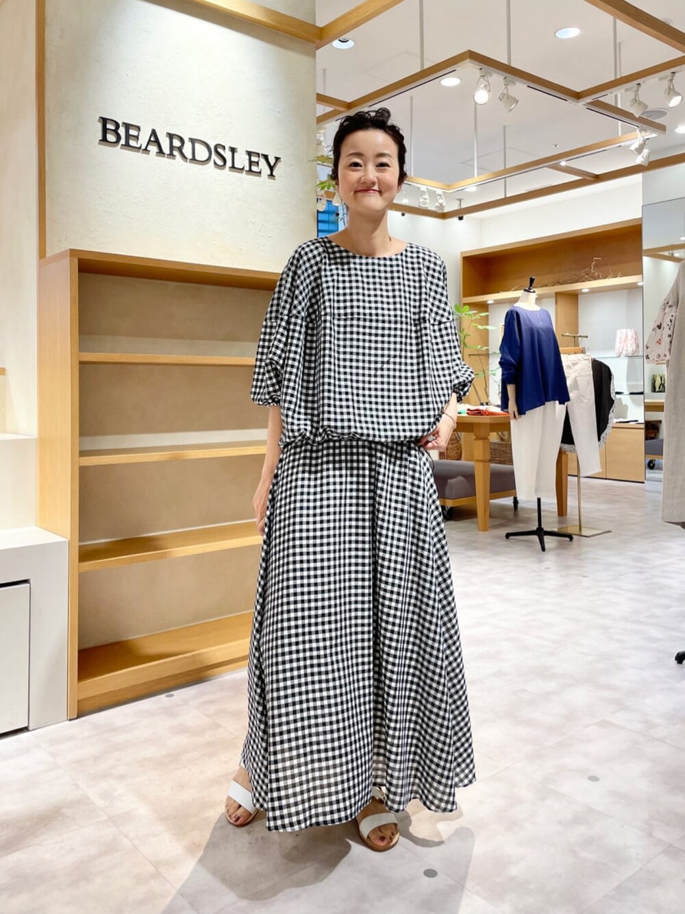 ホワイト系のシャツ/ブラウス、ホワイト系のスカート、ホワイト系のサンダルを着用したレディースの夏コーディネートの4枚目の写真