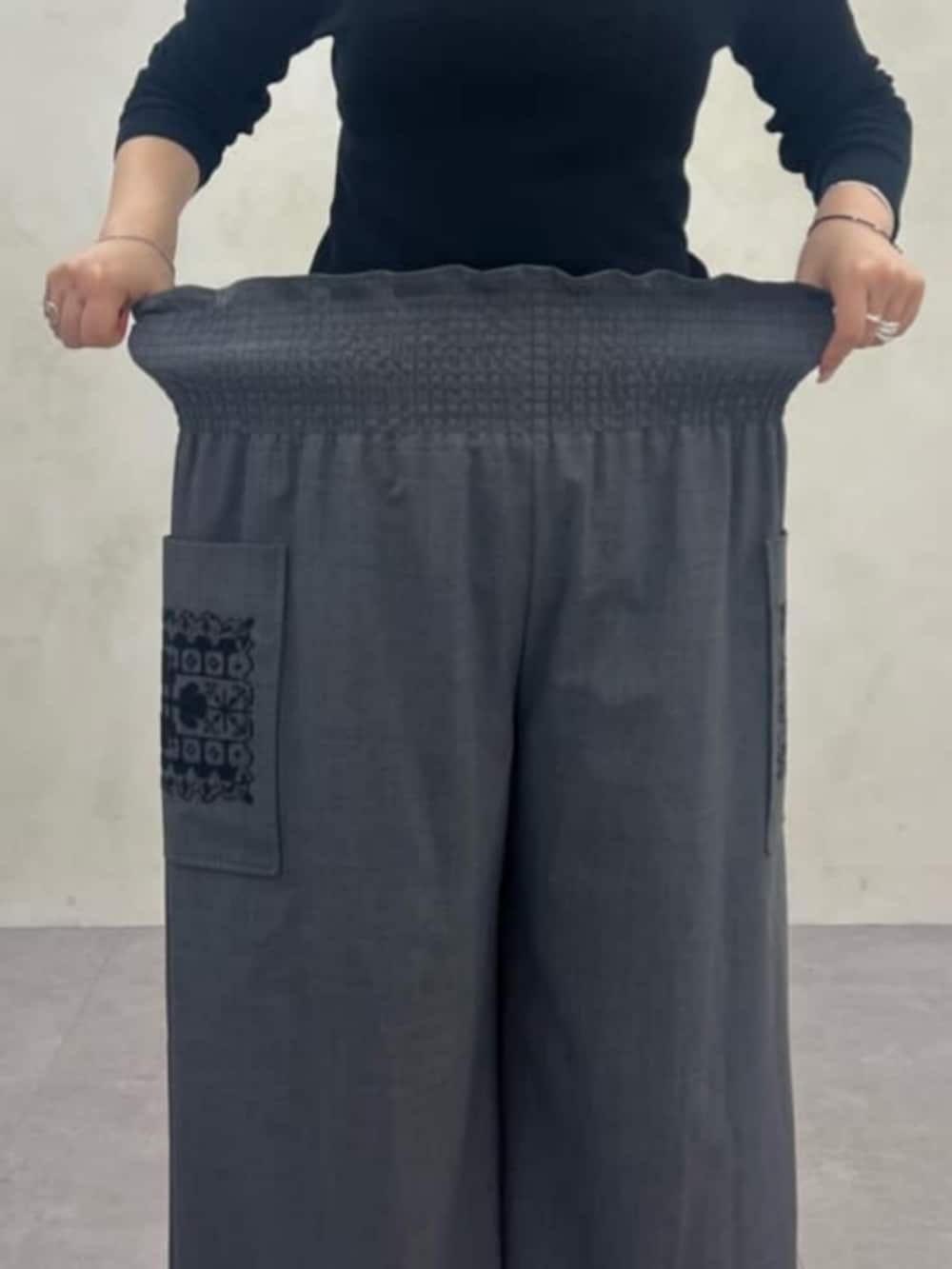 ブラック系のニット/セーター、グレー系のその他パンツ、グレー系のテーラードジャケットを着用したレディースの秋コーディネートの4枚目の写真