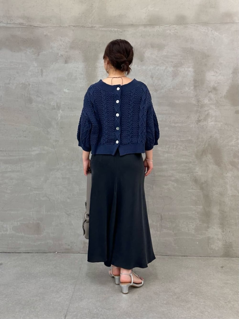 グレー系のショルダーバッグ、ブルー系のニット/セーターを着用したレディースの冬コーディネートの2枚目の写真