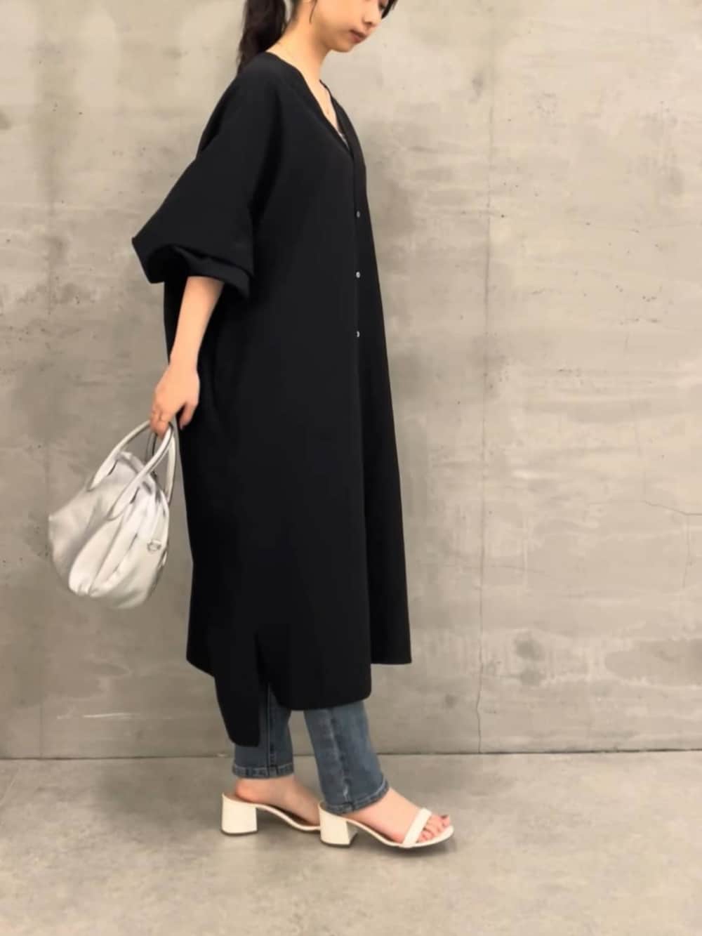 ブルー系のデニムパンツ、ブラック系のワンピースを着用したレディースの冬コーディネートの2枚目の写真