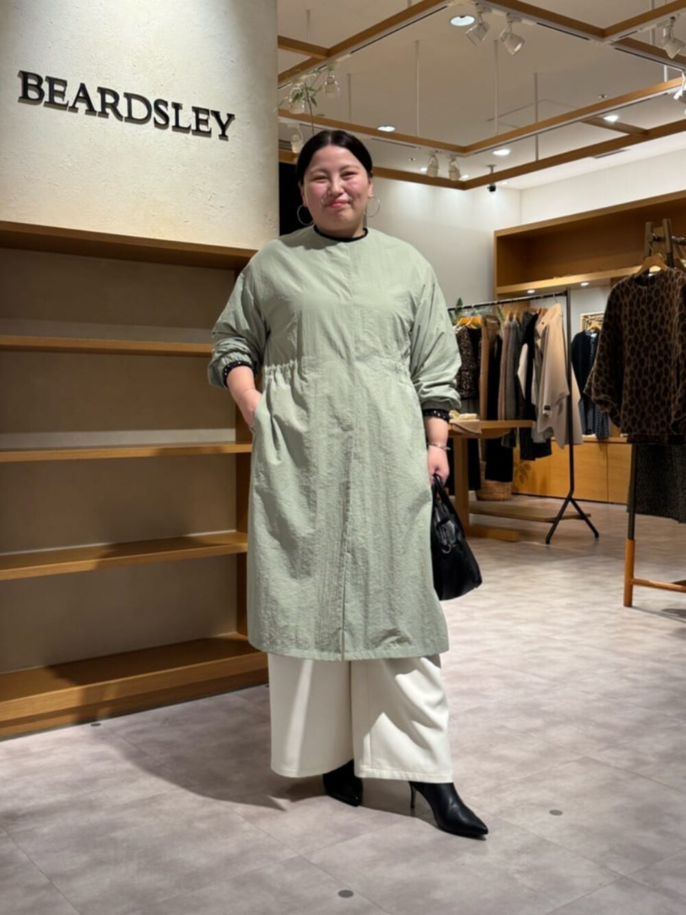 ブラック系のその他パンツ、ブラック系のシャツ/ブラウス、グリーン系のその他アウターを着用したレディースの冬コーディネートの6枚目の写真