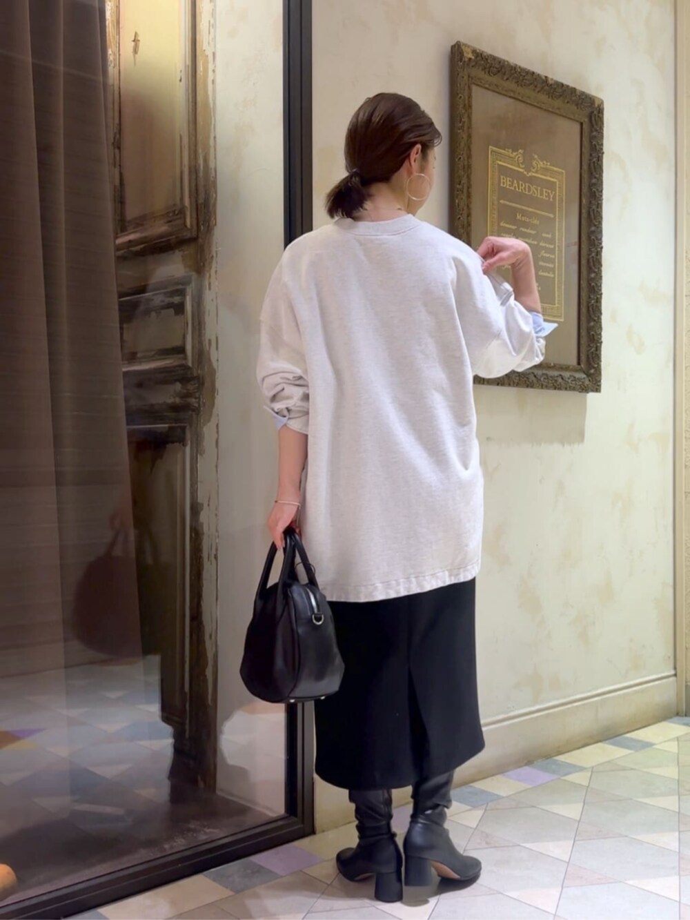 ブラック系のスカート、グレー系のTシャツ/カットソーを着用したレディースの冬コーディネートの2枚目の写真