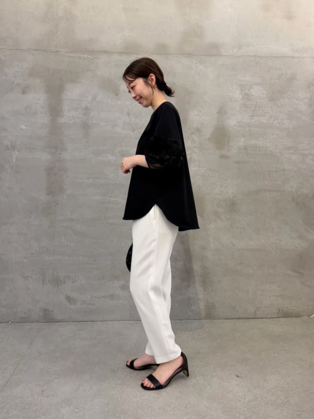 ブラック系のボストンバッグ、ブラック系のTシャツ/カットソー、ホワイト系のその他パンツを着用したレディースの春コーディネートの2枚目の写真