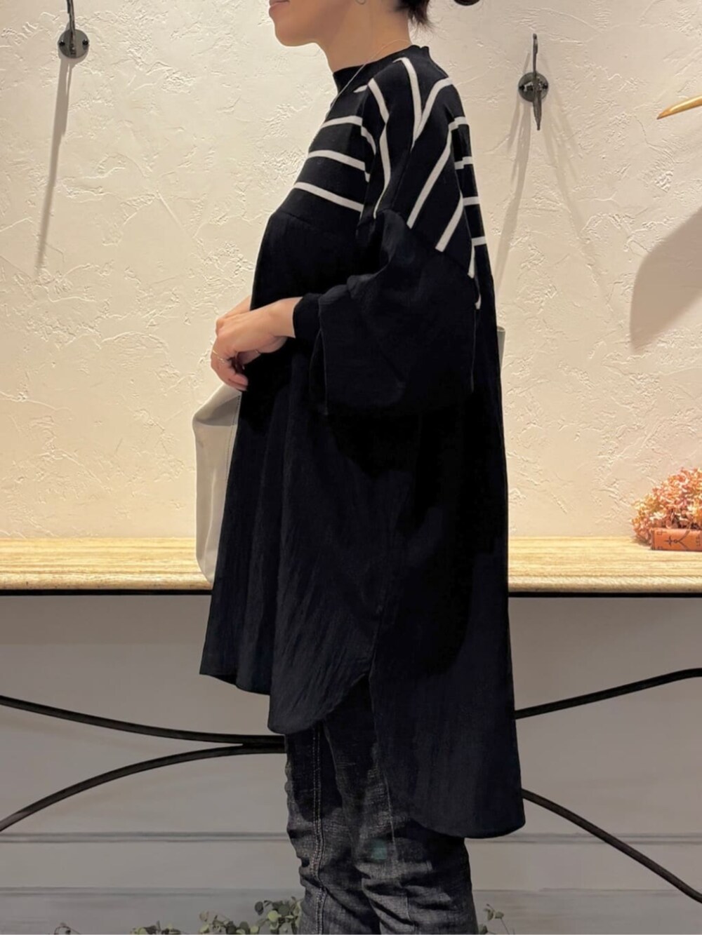 ブラック系のデニムパンツ、ブラック系のニット/セーターを着用したレディースの冬コーディネートの6枚目の写真