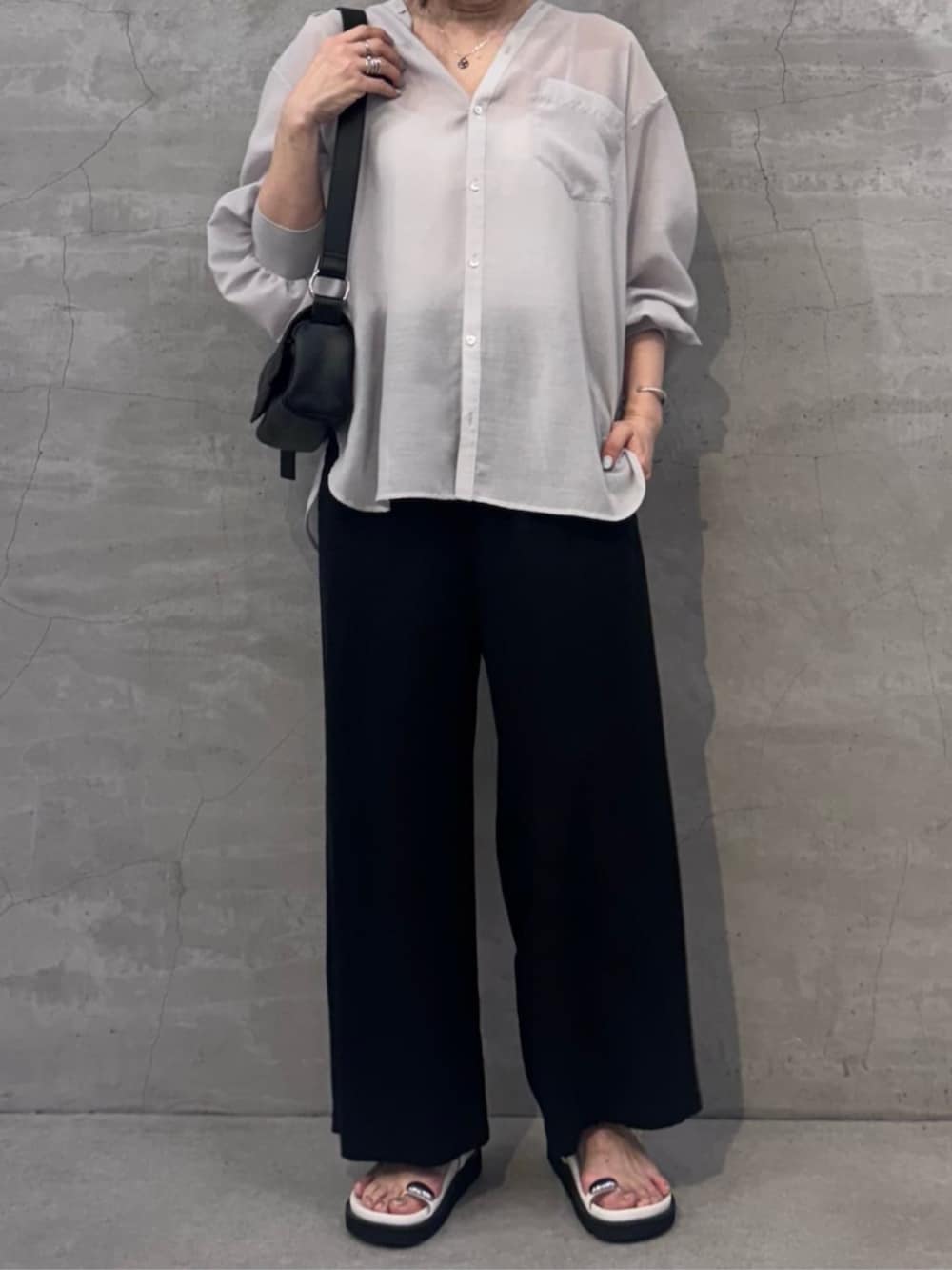 ブラック系のその他パンツ、ブラック系のショルダーバッグ、ホワイト系のサンダルを着用したレディースの冬コーディネートの6枚目の写真