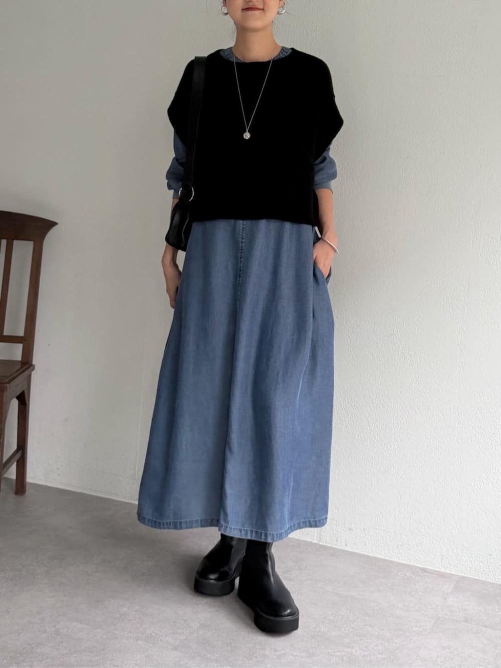 ブルー系のワンピース、ブラック系のベストを着用したレディースの秋コーディネートの3枚目の写真