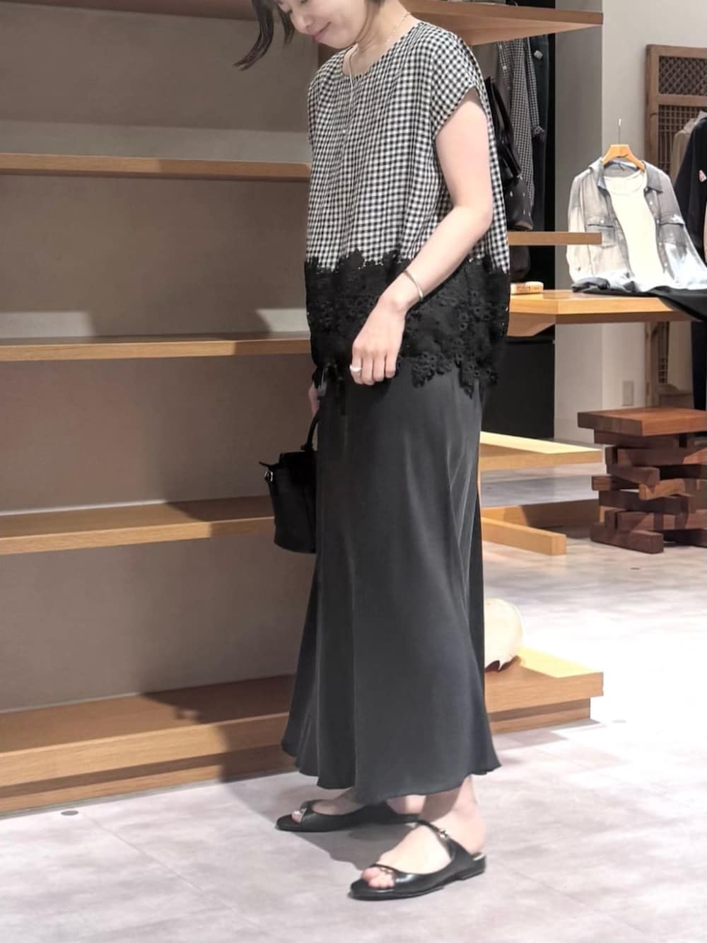 ブラック系のスカート、ブラック系のハンドバッグ、ブラック系のシャツ/ブラウスを着用したレディースの春コーディネートの7枚目の写真