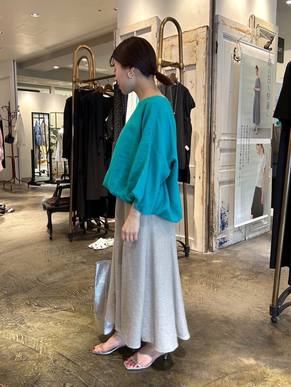 グリーン系のシャツ/ブラウス、ベージュ系のスカート、シルバー系のトートバッグを着用したレディースの夏コーディネートの2枚目の写真