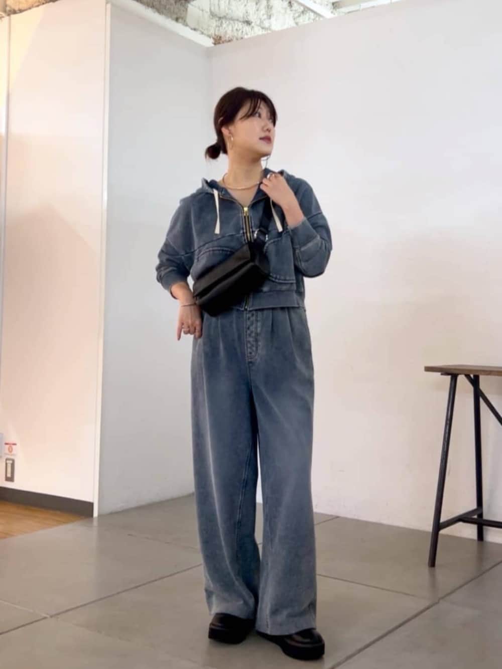 ブラック系のショルダーバッグ、ブルー系のその他パンツ、ブルー系のパーカーを着用したレディースの秋コーディネートの5枚目の写真