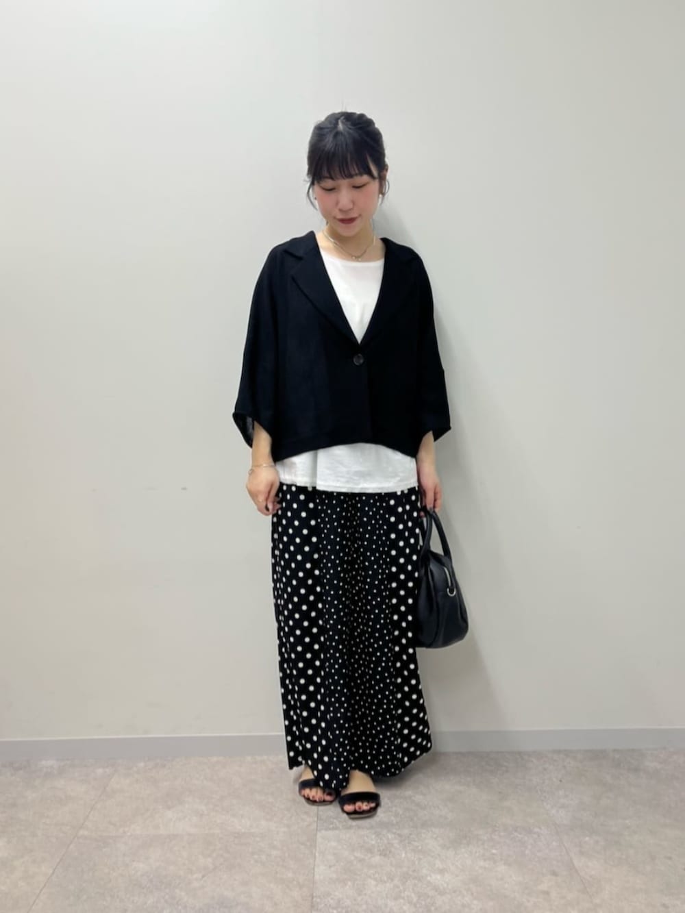 ブラック系のボストンバッグ、ホワイト系のシャツ/ブラウス、ブラック系のその他パンツを着用したレディースの春コーディネートの3枚目の写真