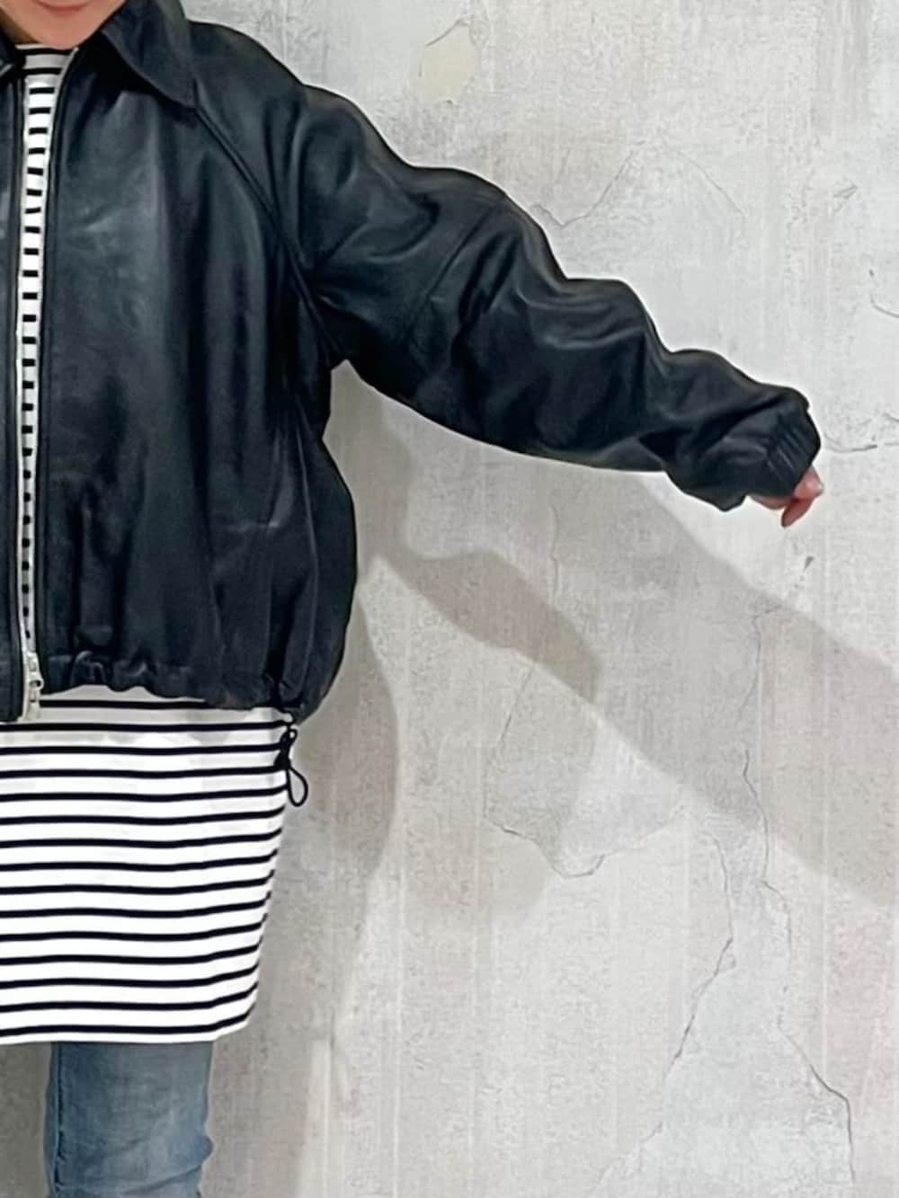 ブルー系のデニムパンツ、ブラック系のブルゾンを着用したレディースの冬コーディネートの7枚目の写真