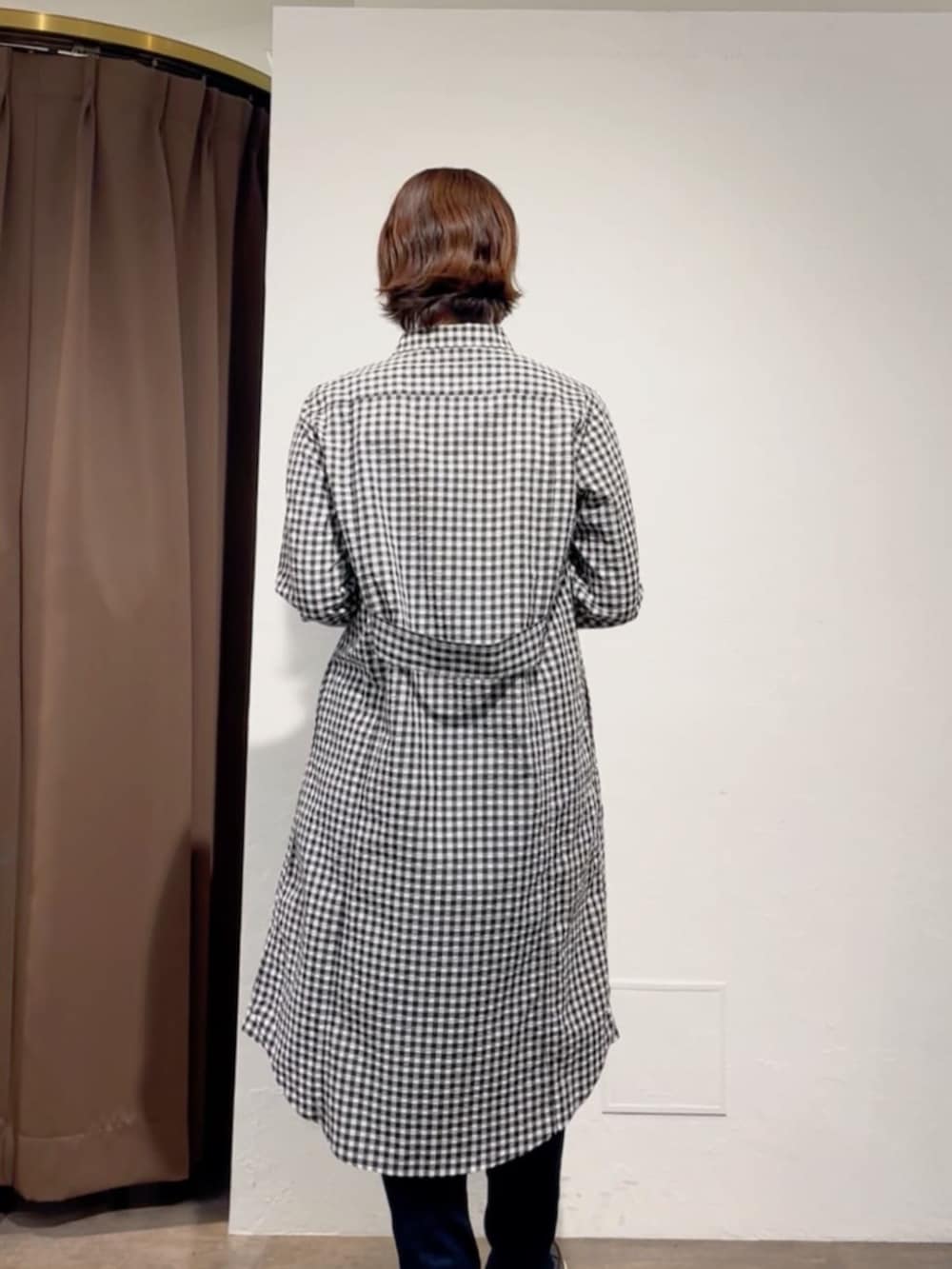 ブルー系のデニムパンツ、ブラック系のワンピース、ホワイト系のトートバッグを着用したレディースの春コーディネートの7枚目の写真