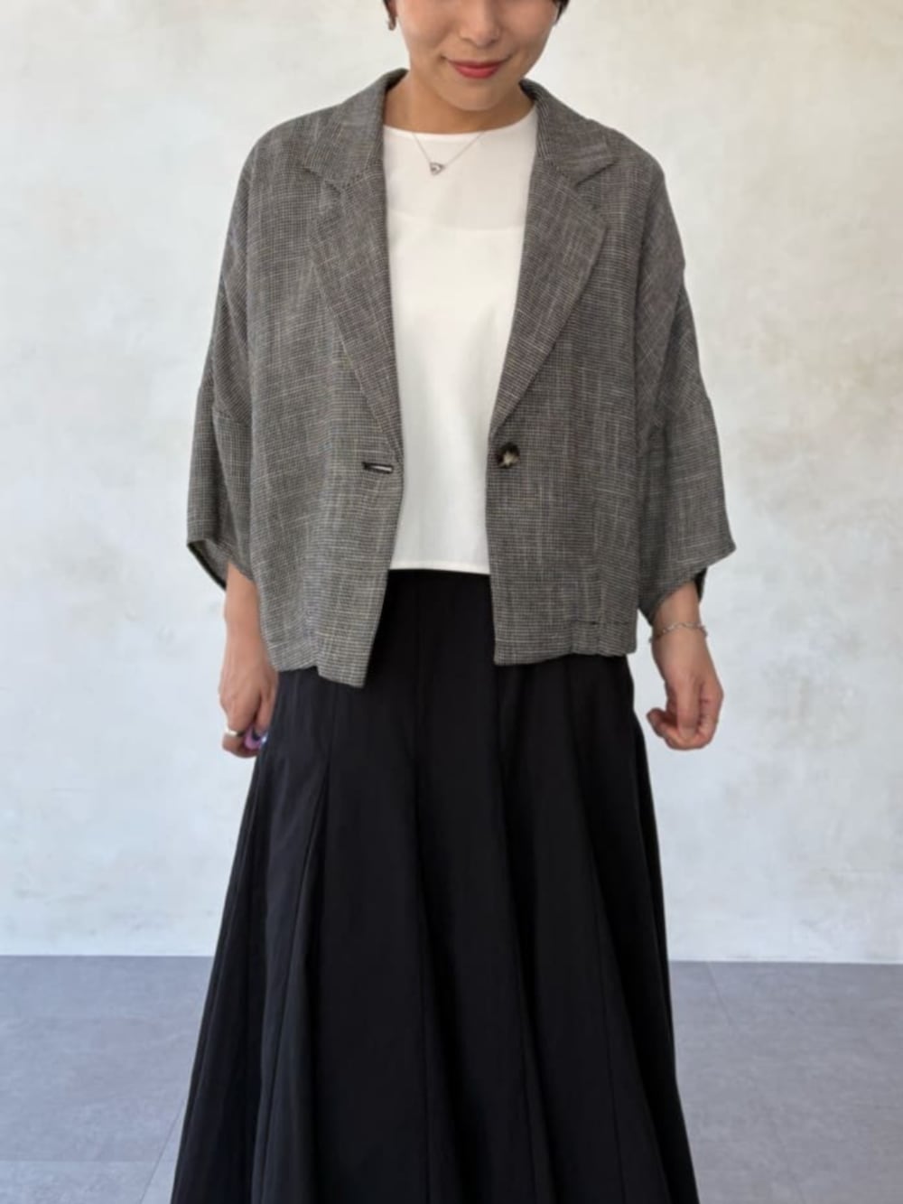 ベージュ系のテーラードジャケット、ホワイト系のシャツ/ブラウス、ブラック系のスカートを着用したレディースの春コーディネートの6枚目の写真