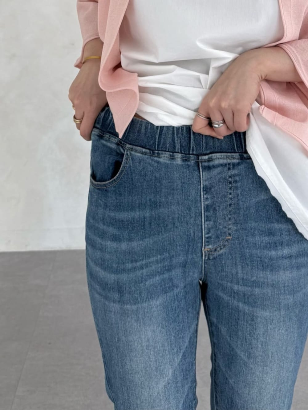 ホワイト系のタンクトップ、ブルー系のデニムパンツ、ピンク系のカーディガン/ボレロを着用したレディースの春コーディネートの8枚目の写真
