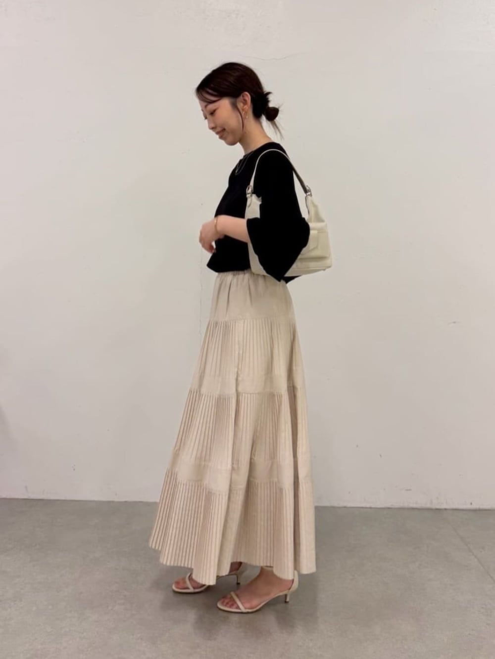 ホワイト系のスカート、ブラック系のシャツ/ブラウスを着用したレディースの春コーディネートの2枚目の写真