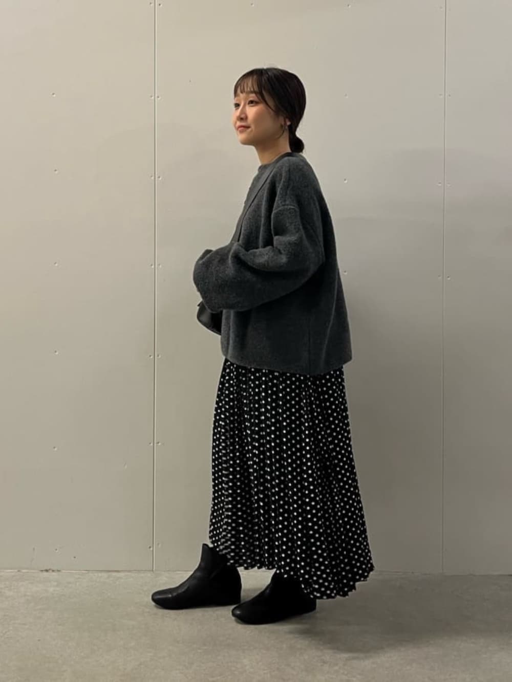 ブラック系のワンピース、ブラック系のブーツ、グレー系のニット/セーターを着用したレディースの冬コーディネートの6枚目の写真