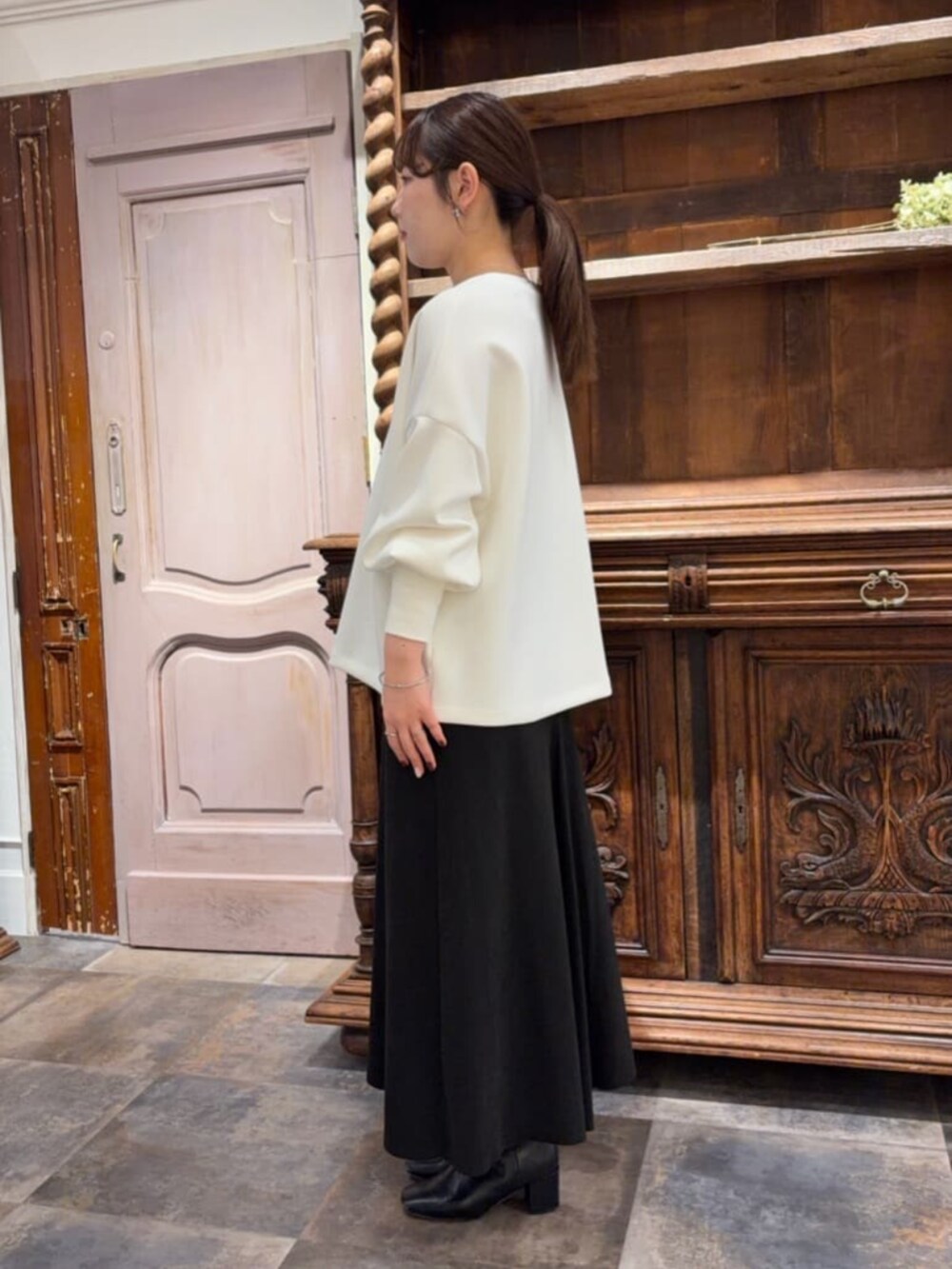 ブラック系のスカート、ブラック系のショルダーバッグ、ホワイト系のTシャツ/カットソーを着用したレディースの冬コーディネートの3枚目の写真