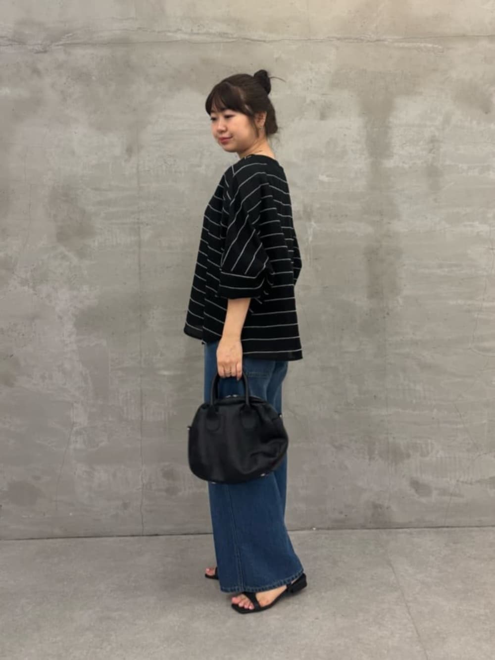 ブラック系のボストンバッグ、ブルー系のその他パンツ、ブラック系のシャツ/ブラウスを着用したレディースの春コーディネートの2枚目の写真