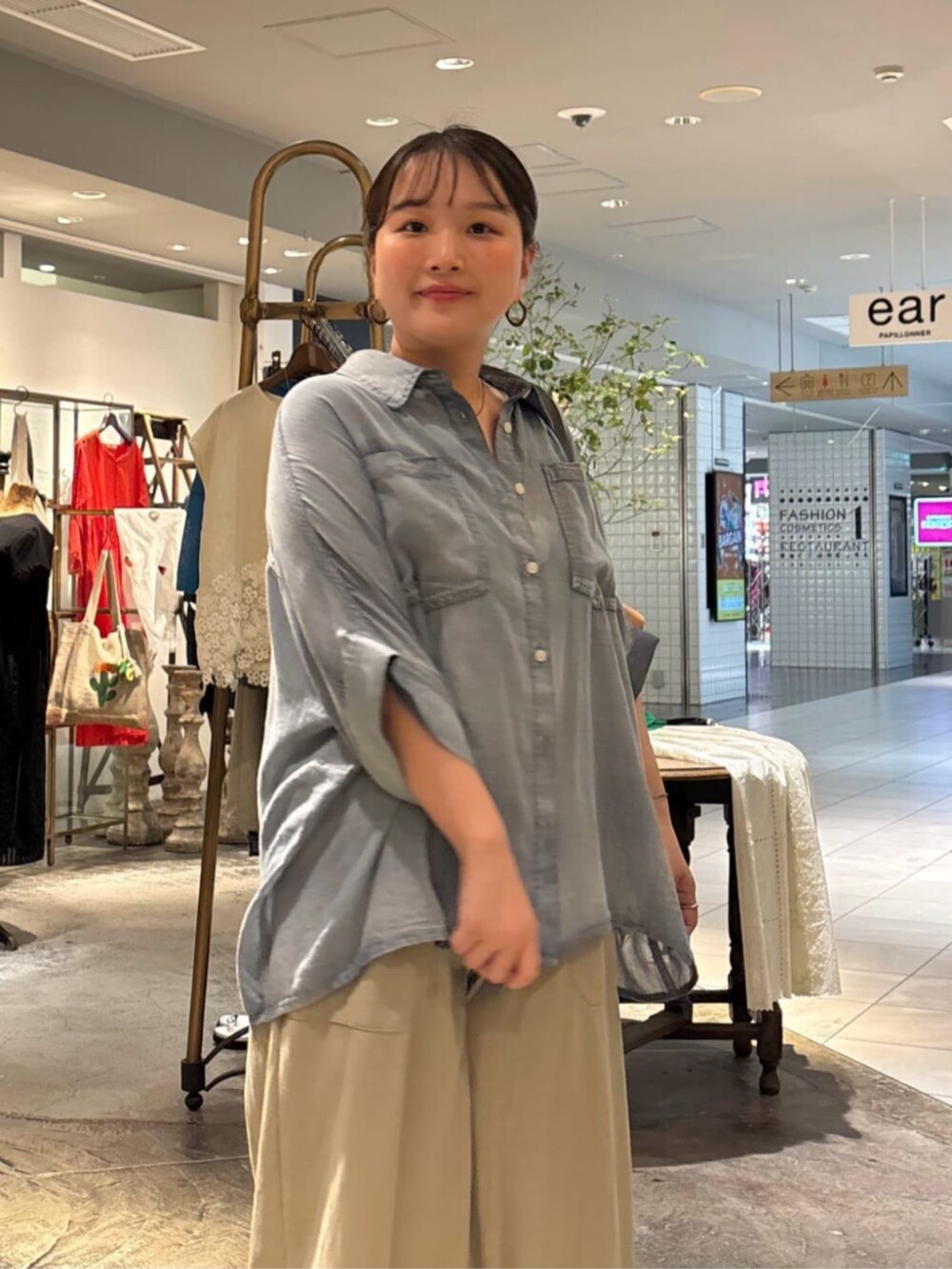 ブルー系のシャツ/ブラウス、グリーン系のベストを着用したレディースの夏コーディネートの5枚目の写真