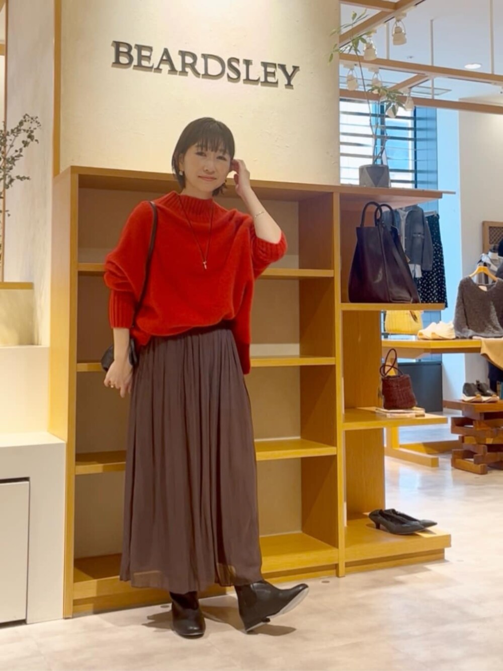 ブラウン系のその他パンツ、ブラック系のノーカラーコート、ブラック系のブーツを着用したレディースの冬コーディネートの6枚目の写真