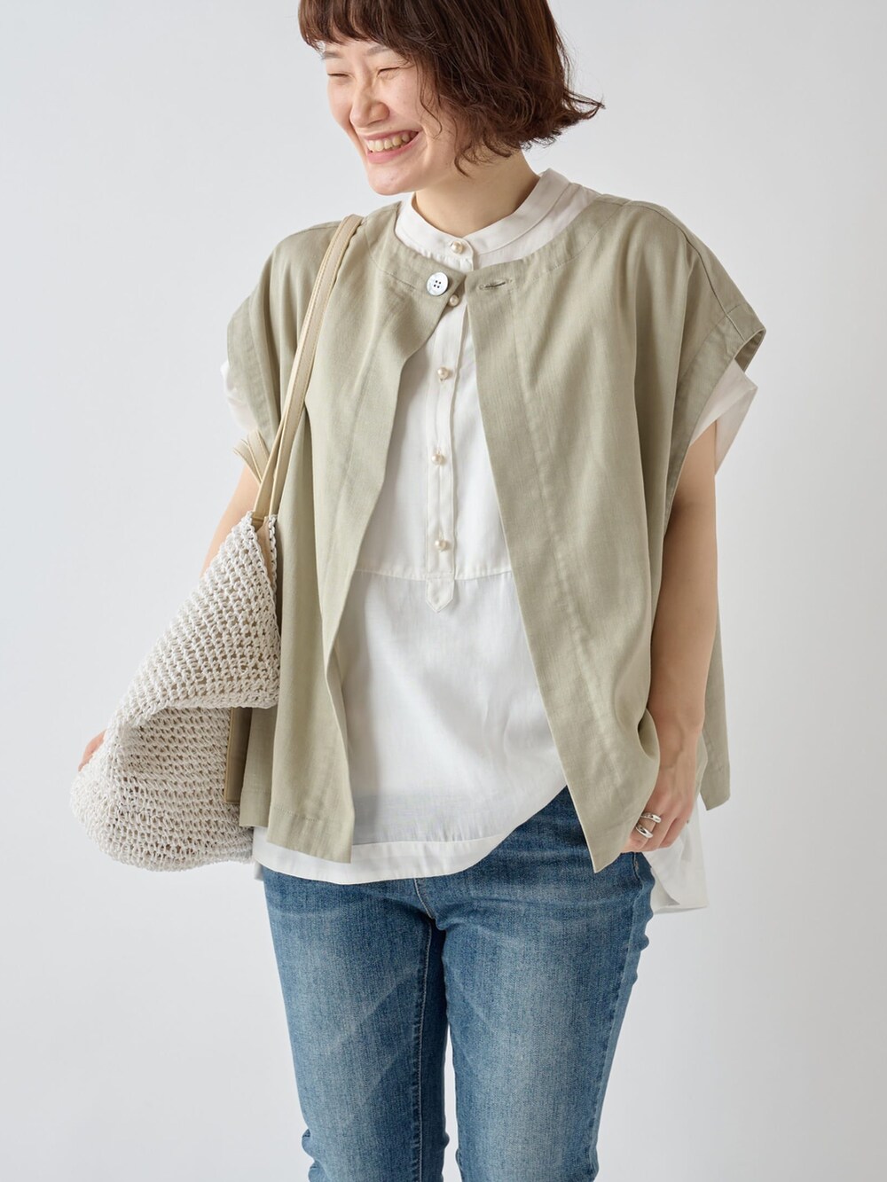 ホワイト系のシャツ/ブラウス、ホワイト系のトートバッグ、ベージュ系のベストを着用したレディースの夏コーディネートの3枚目の写真