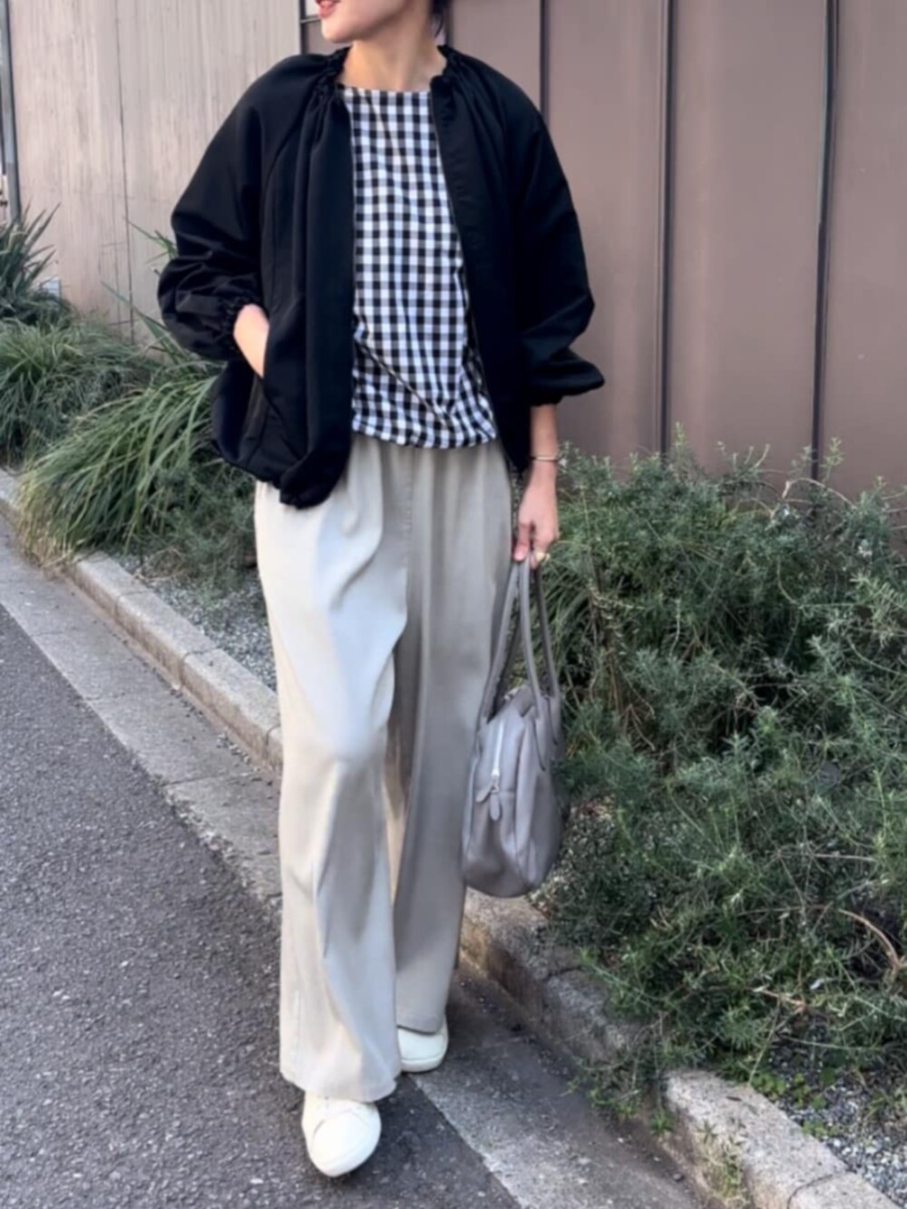 グレー系のボストンバッグ、ブラック系のノーカラージャケット、ブラック系のシャツ/ブラウスを着用したレディースの春コーディネートの3枚目の写真