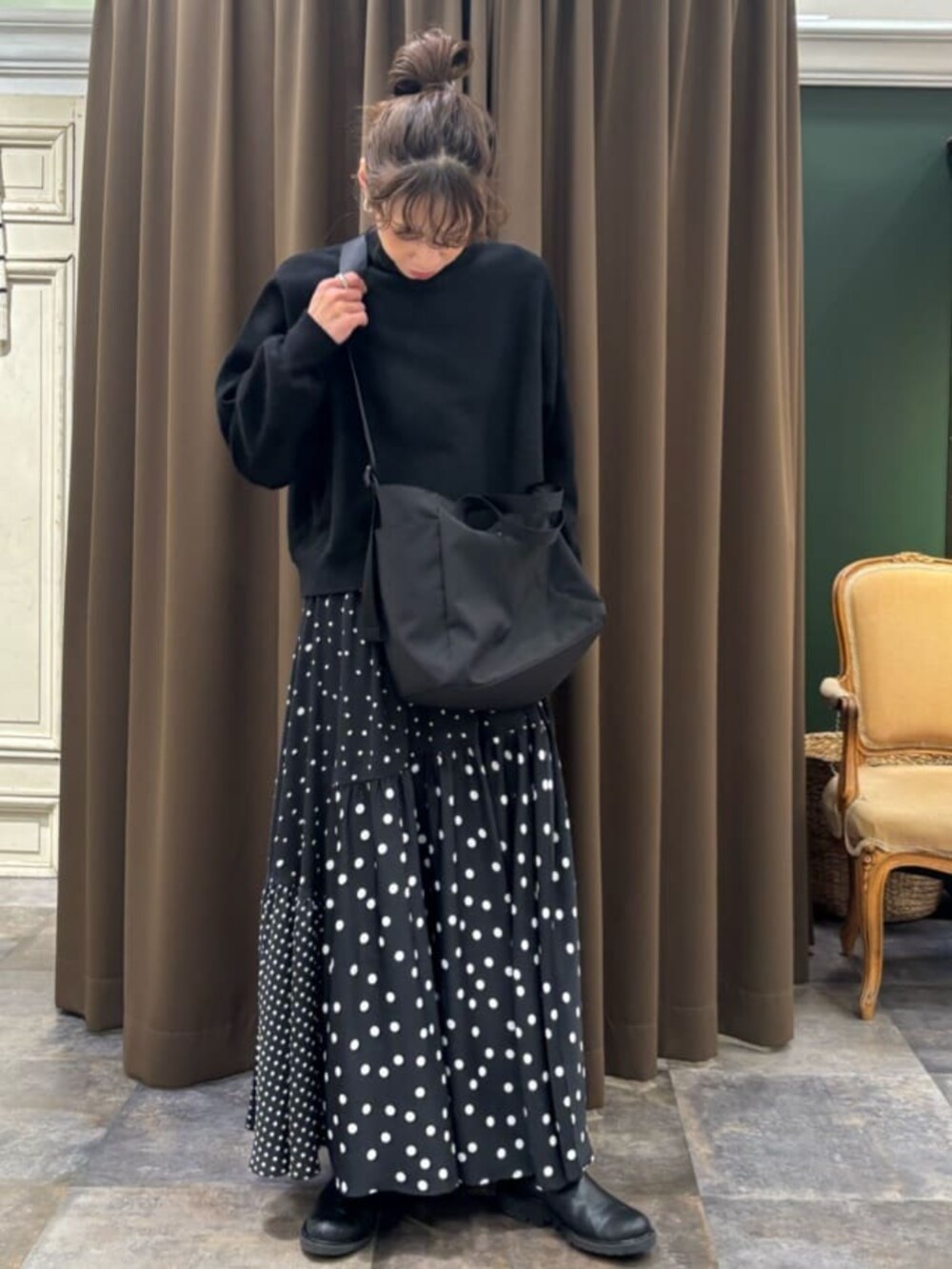 ブラック系のトートバッグを着用したレディースの冬コーディネートの2枚目の写真