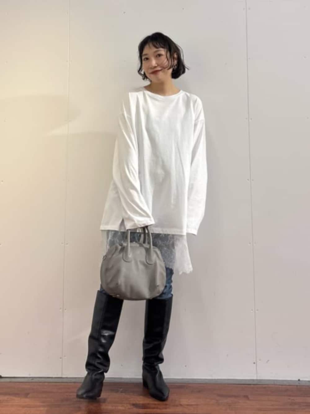 ブルー系のデニムパンツ、グレー系のトートバッグ、ホワイト系のTシャツ/カットソーを着用したレディースの秋コーディネートの5枚目の写真