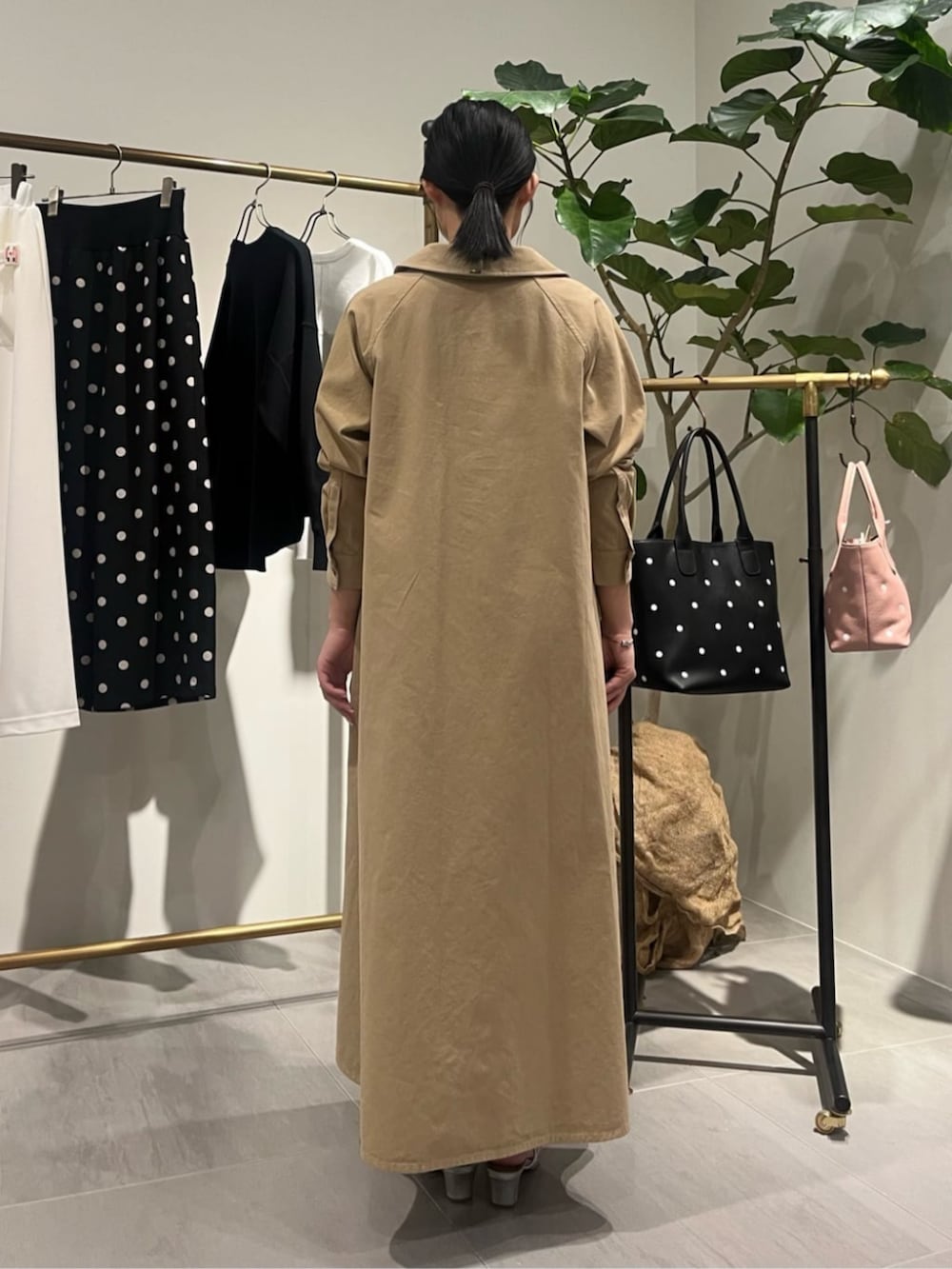 ブラック系のショルダーバッグ、ベージュ系のワンピースを着用したレディースの春コーディネートの5枚目の写真