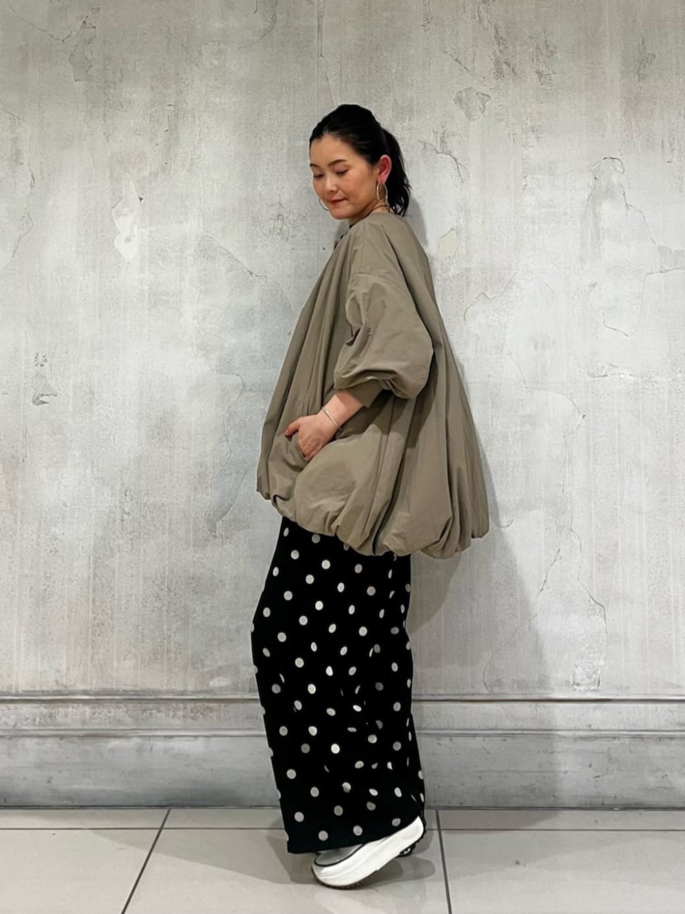 ブラック系のハンドバッグ、ブラック系のその他パンツ、ブラウン系のブルゾンを着用したレディースの春コーディネートの5枚目の写真