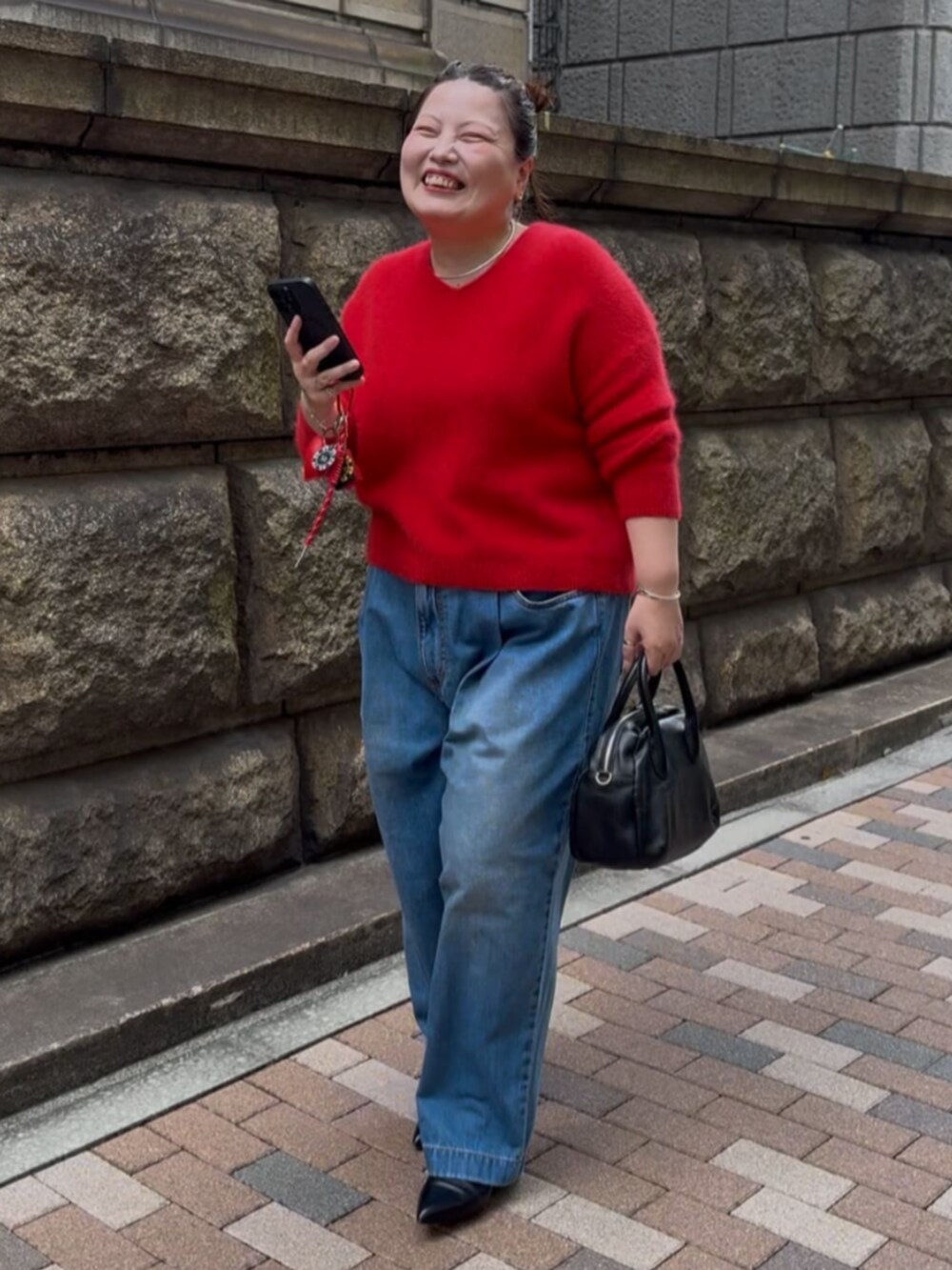 レッド系のニット/セーター、レッド系のチャームを着用したレディースの秋コーディネートの4枚目の写真