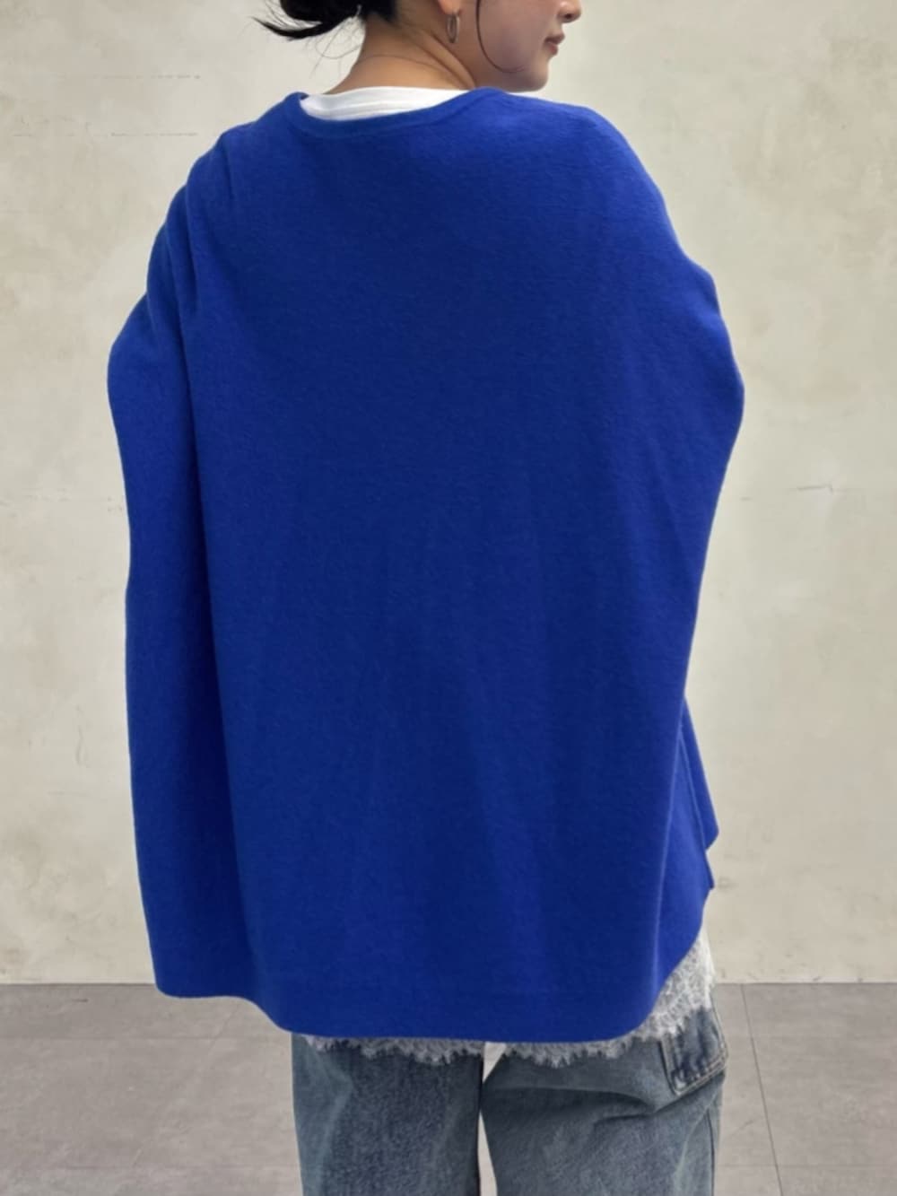 ブルー系のデニムパンツ、ブルー系のニット/セーター、ホワイト系のTシャツ/カットソーを着用したレディースの秋コーディネートの9枚目の写真