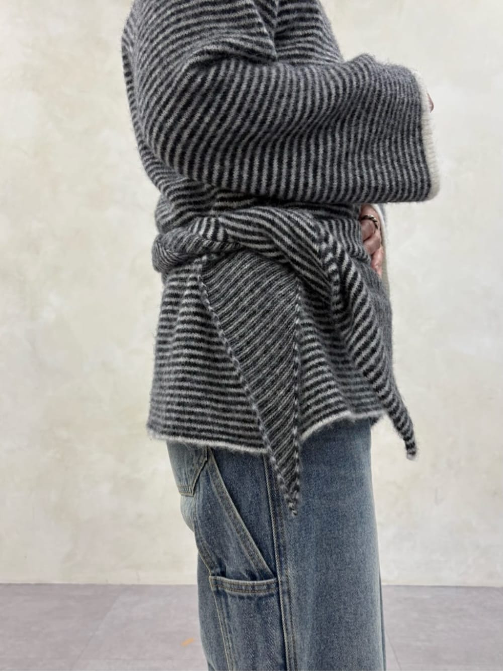 ブルー系のデニムパンツ、ブラック系のブーツ、ブラック系のニット/セーターを着用したレディースの秋コーディネートの8枚目の写真