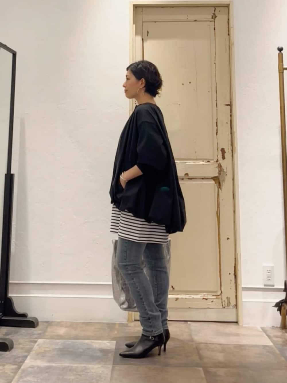 ブルー系のデニムパンツ、ブルー系のTシャツ/カットソー、ブラック系のトートバッグを着用したレディースの冬コーディネートの2枚目の写真