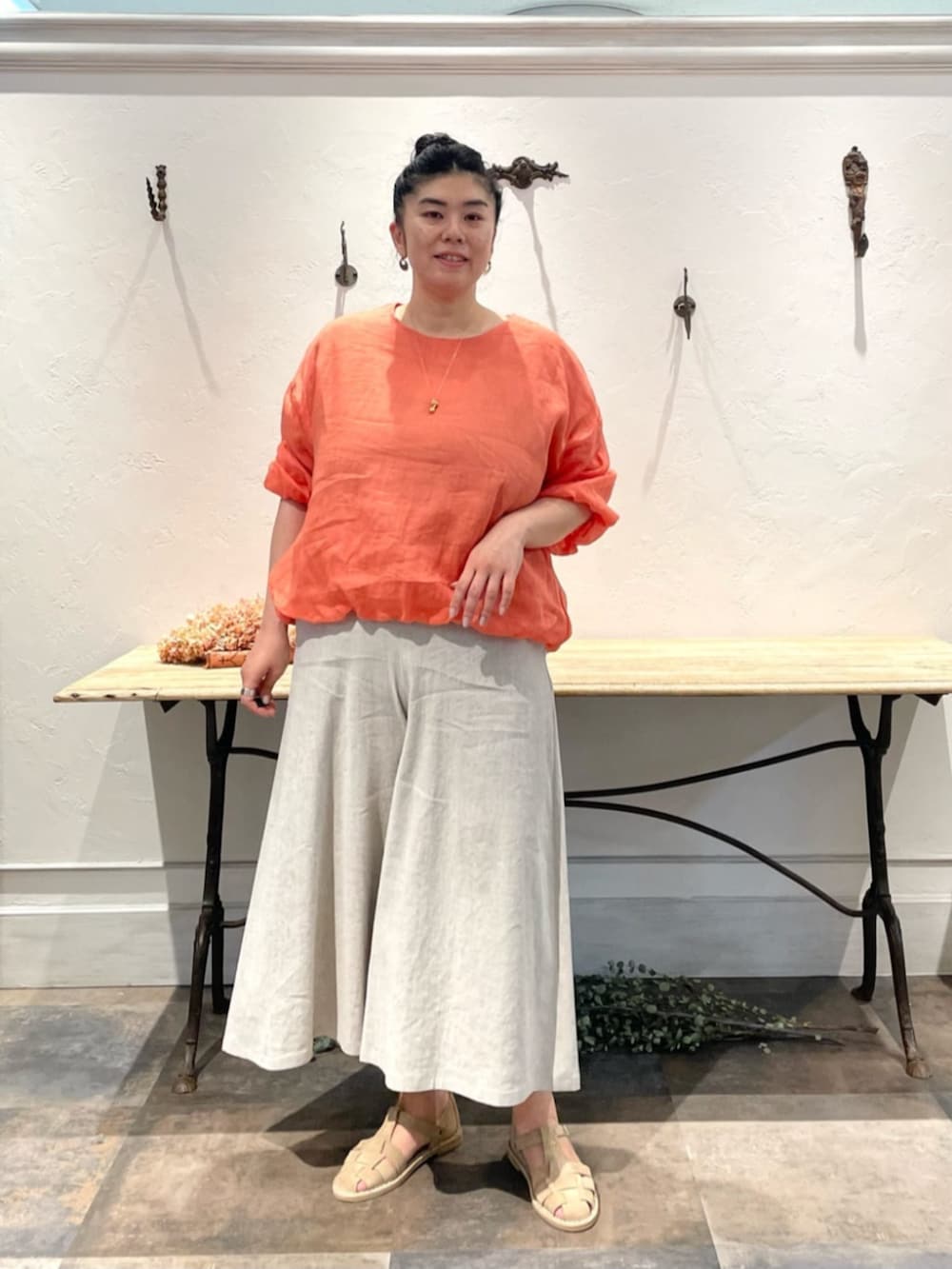 ベージュ系のその他パンツ、オレンジ系のシャツ/ブラウス、ゴールド系のリングを着用したレディースの春コーディネートの3枚目の写真