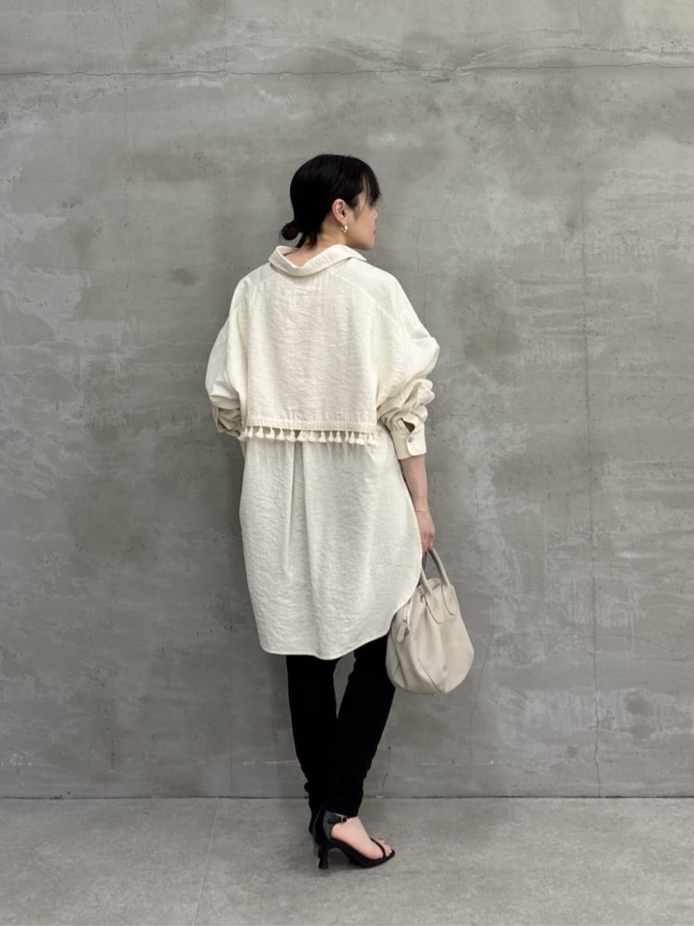 グレー系のボストンバッグ、ホワイト系のシャツ/ブラウスを着用したレディースの冬コーディネートの3枚目の写真