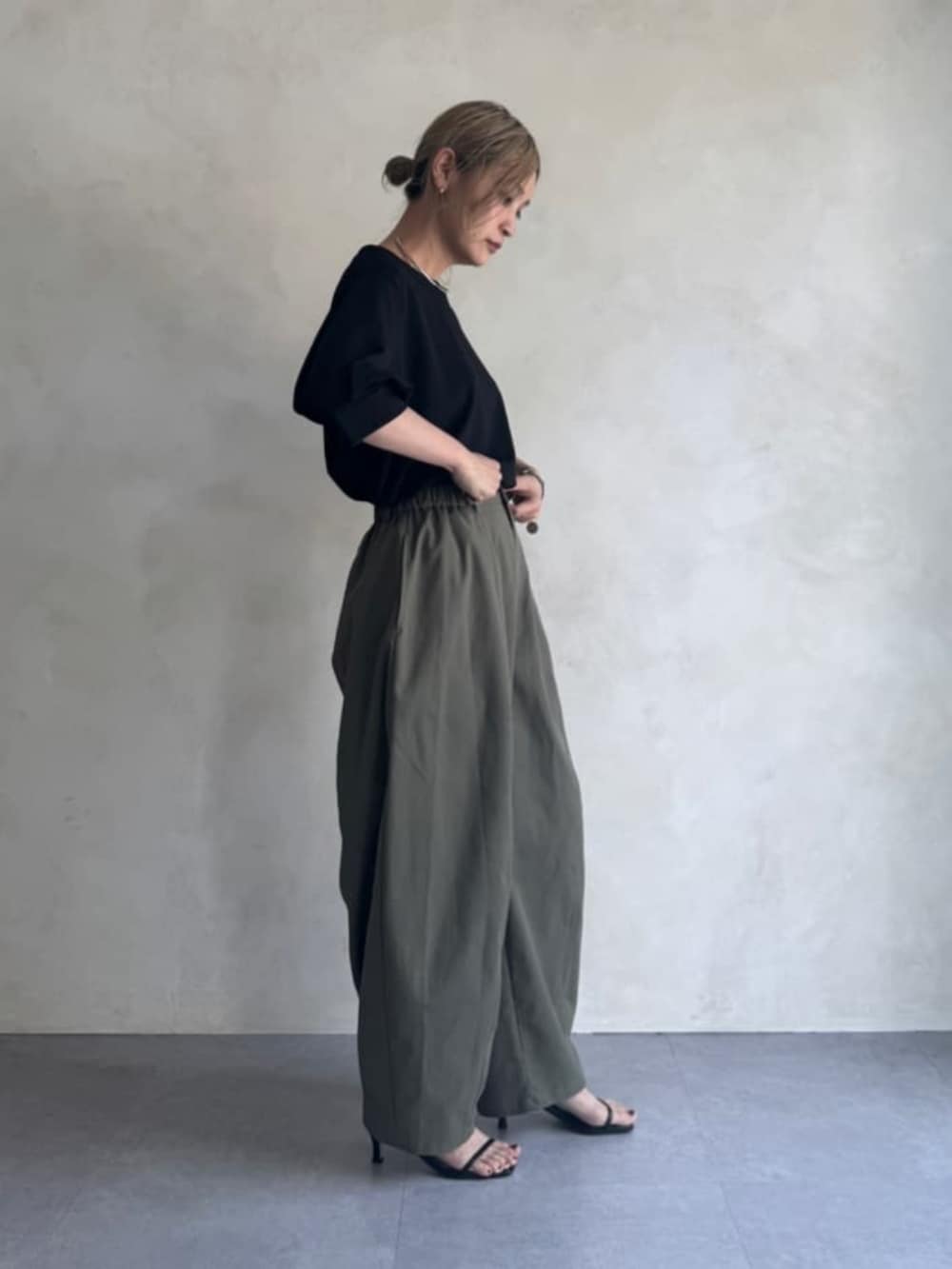グリーン系のその他パンツ、ブラック系のTシャツ/カットソーを着用したレディースの夏コーディネートの3枚目の写真