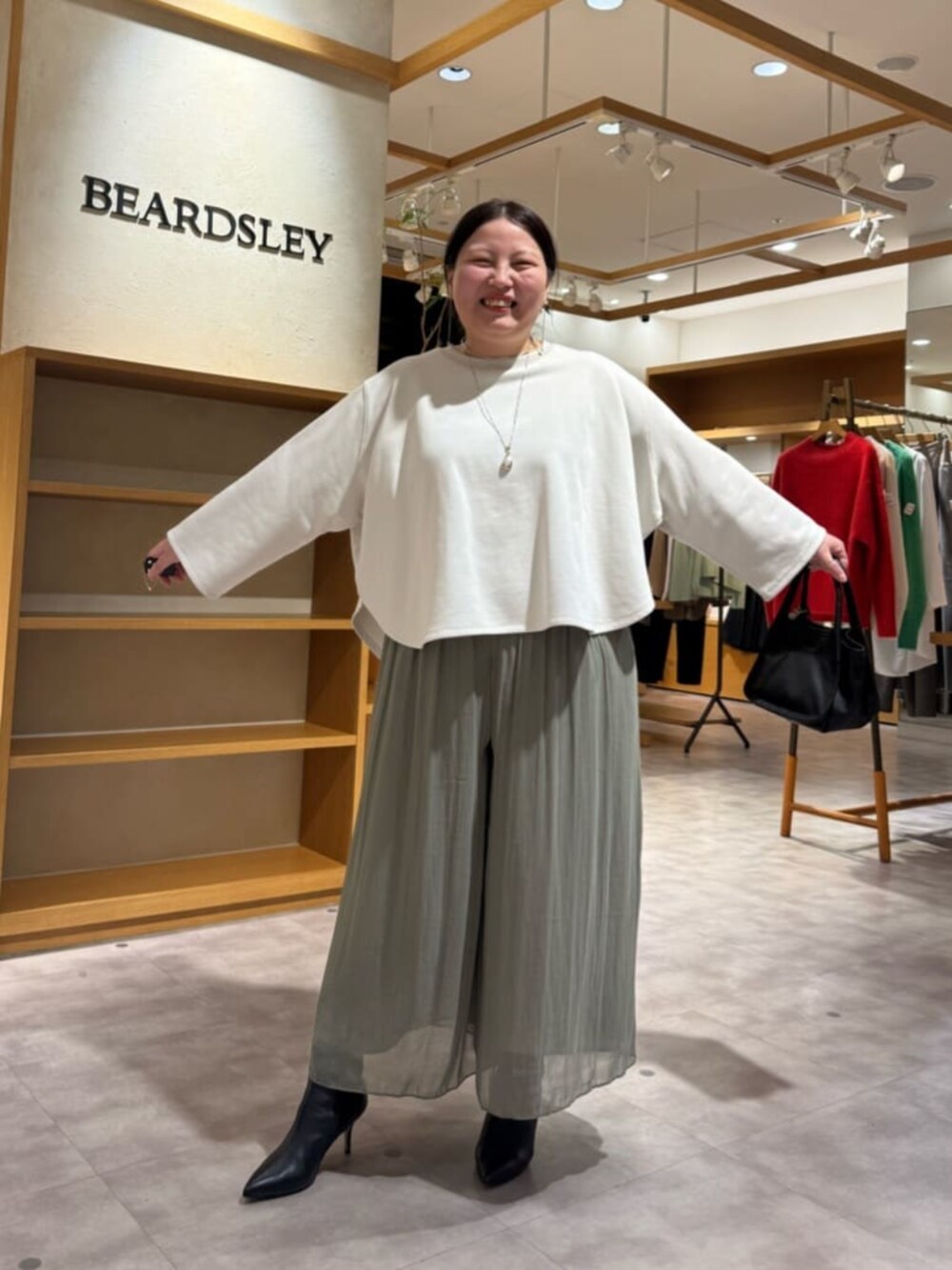 グリーン系のその他パンツ、ブラック系のブーツ、ブラック系のトートバッグを着用したレディースの冬コーディネートの3枚目の写真