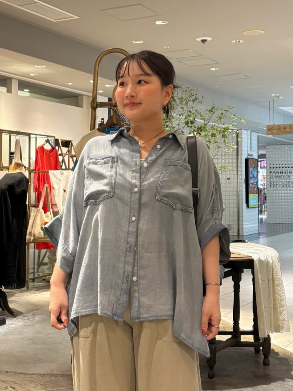 ブルー系のシャツ/ブラウス、グリーン系のベストを着用したレディースの夏コーディネートの4枚目の写真